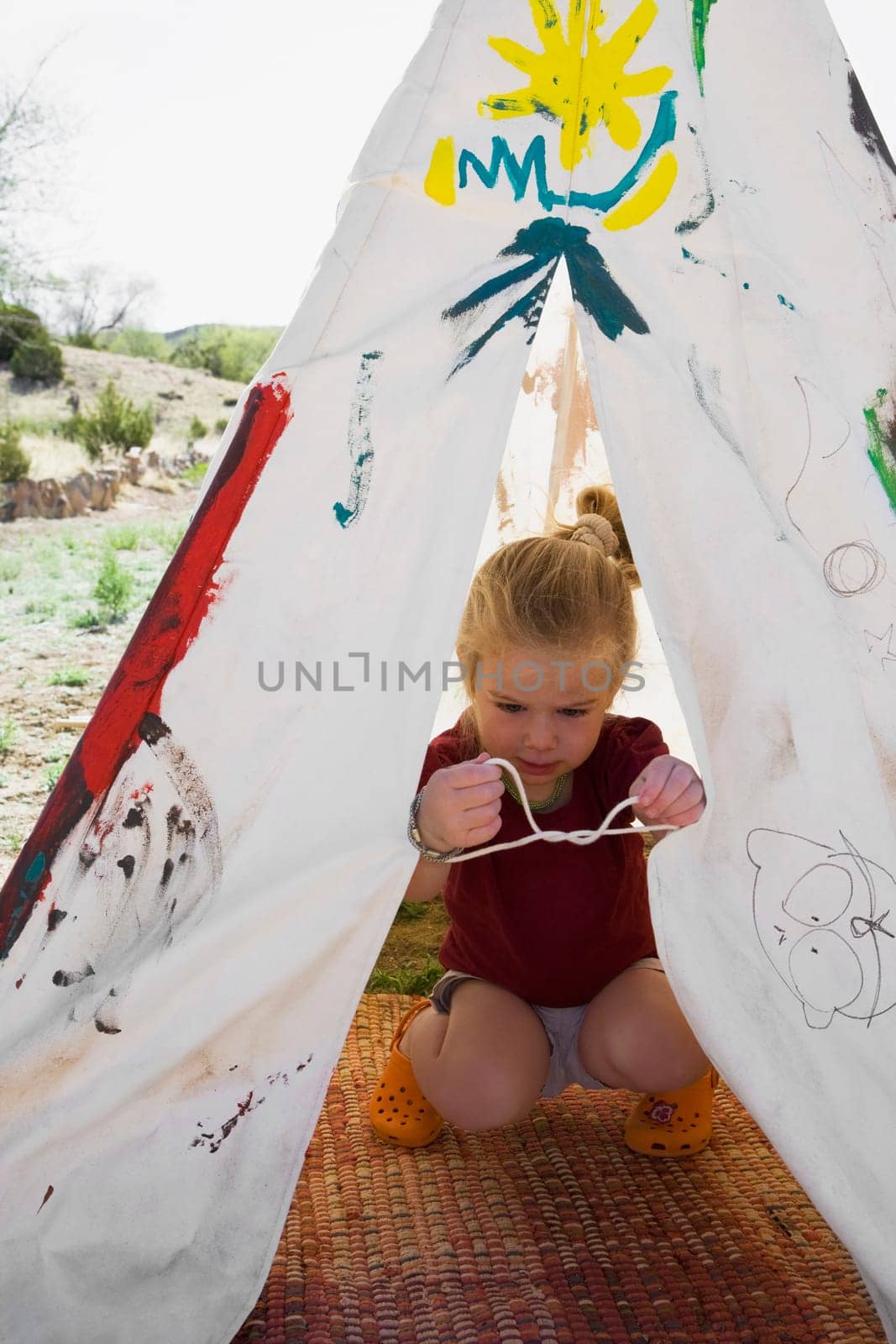 Girl tying knot of a tent, Santa Fe, New Mexico, USA