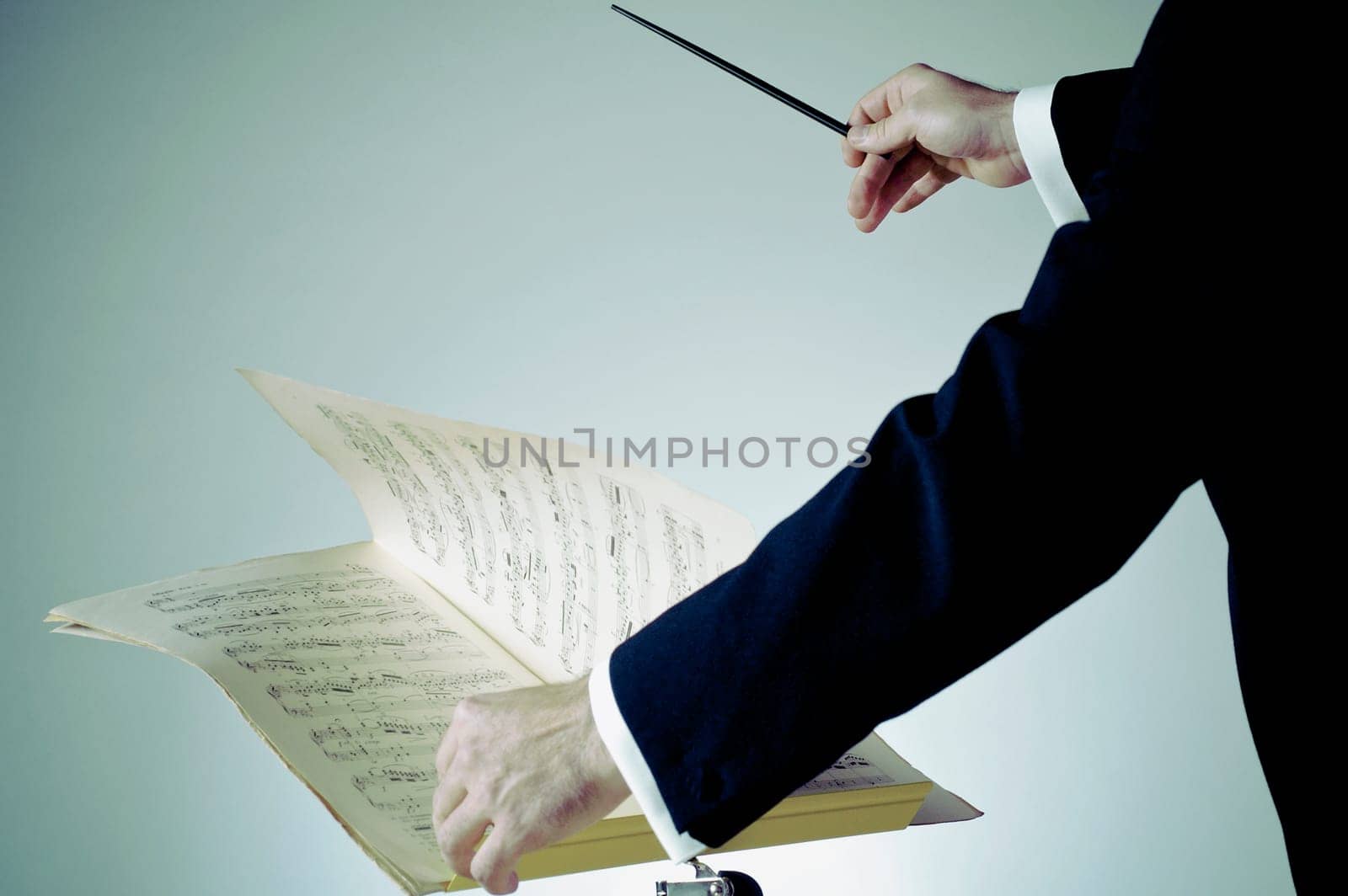 Mid section view of a music conductor performing
