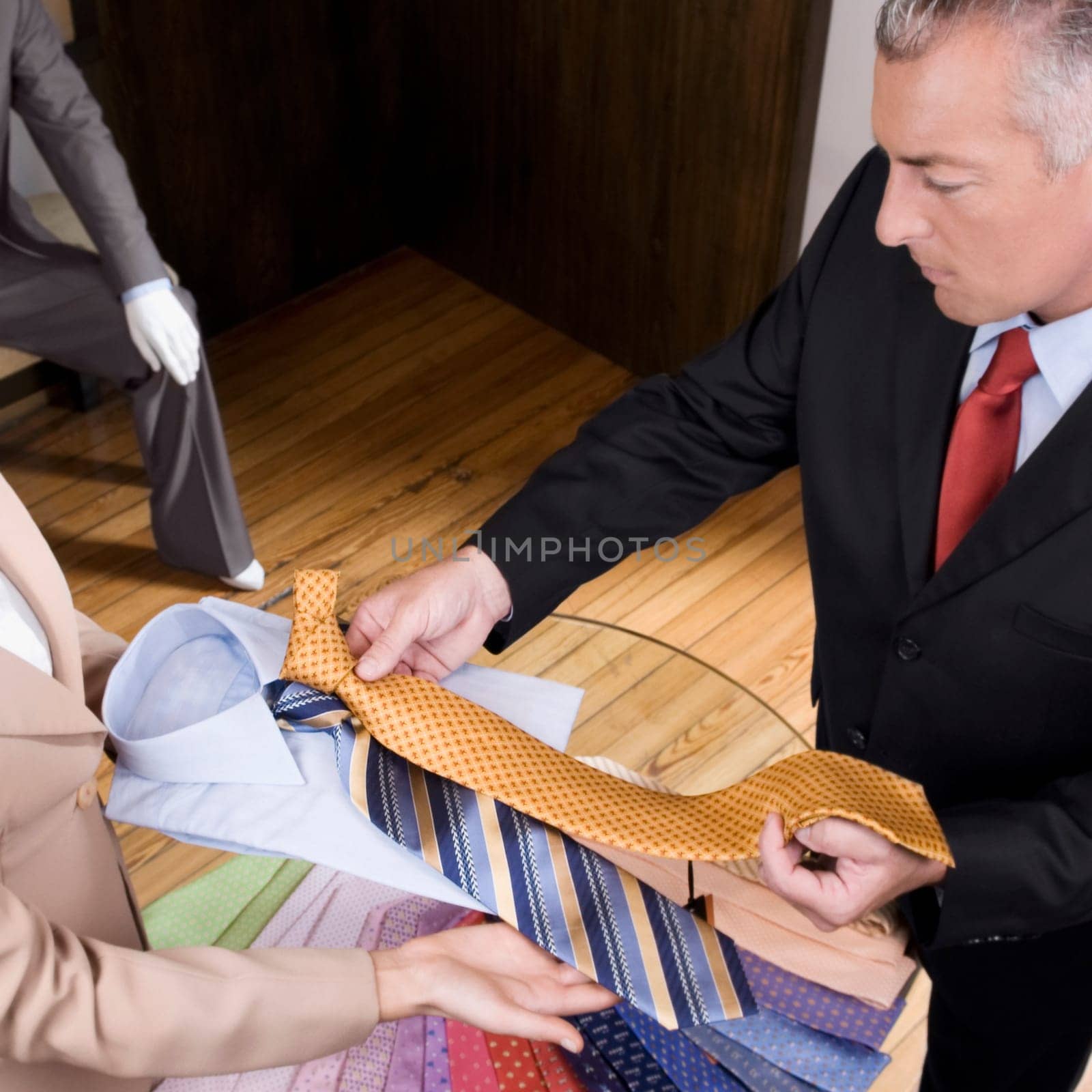 Saleswoman assisting a businessman in a clothing store