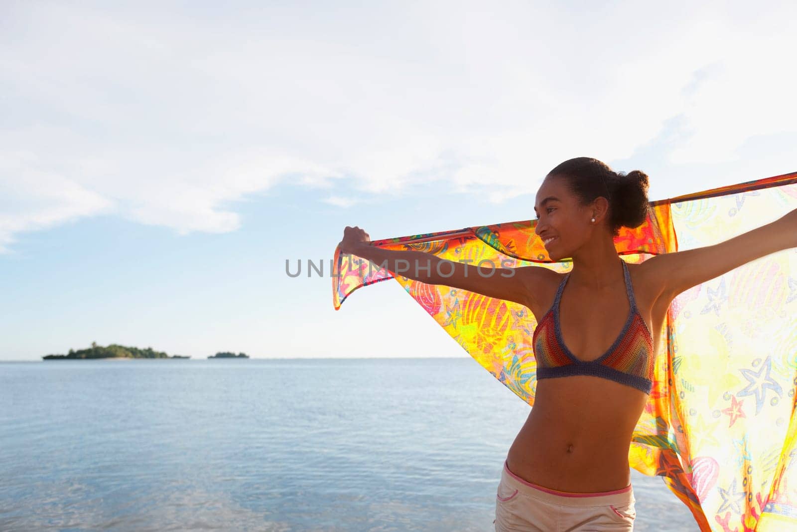 Woman holding a sarong on the beach
