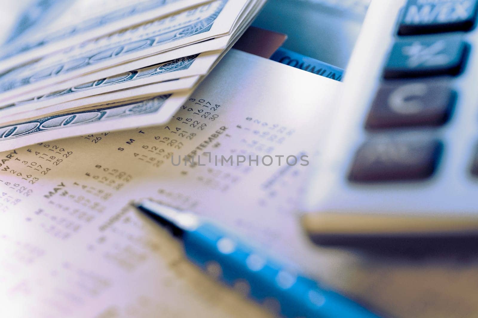 Money with a pen and a calculator on a calendar