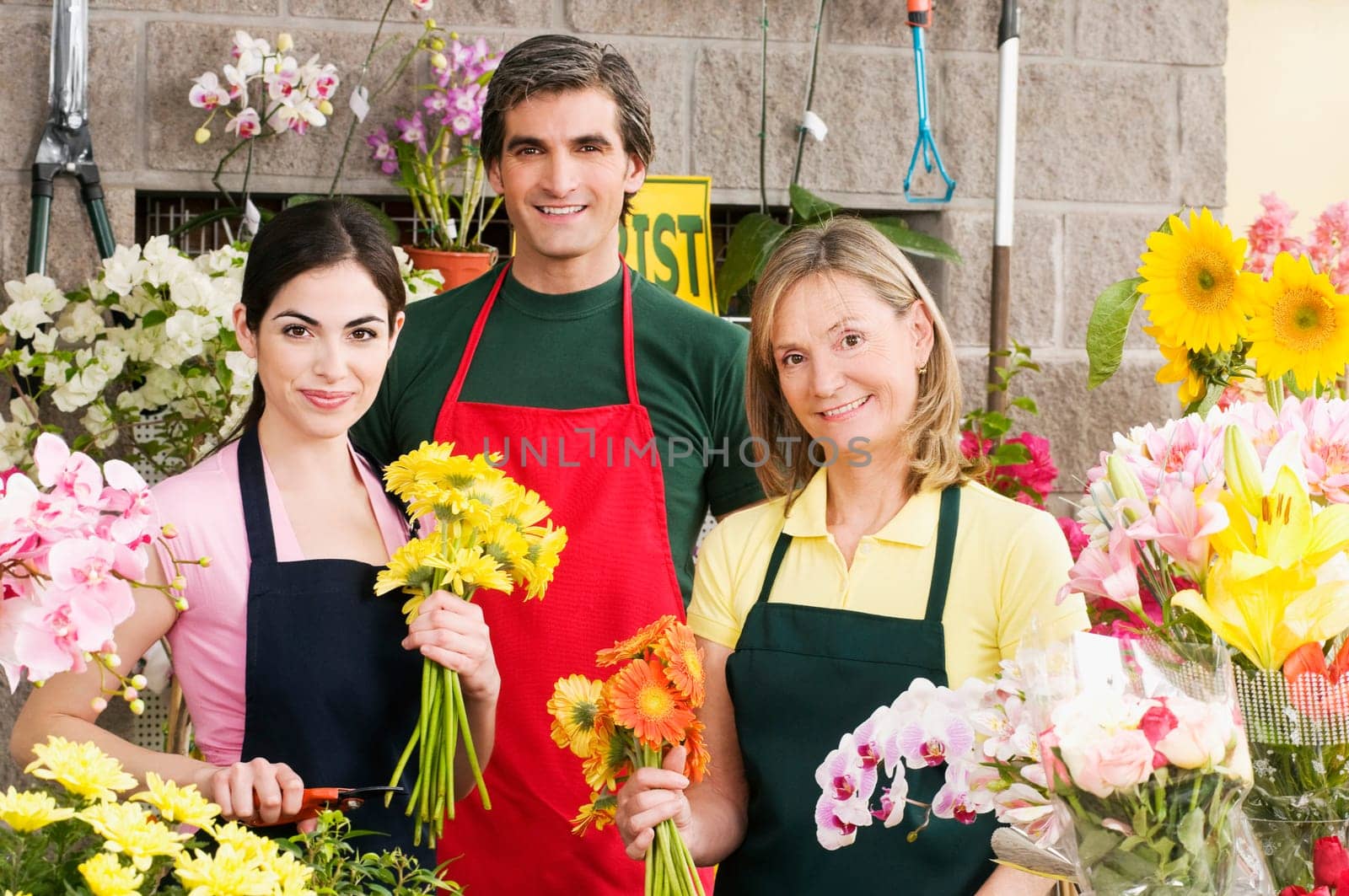Two female florists with a male florist smiling