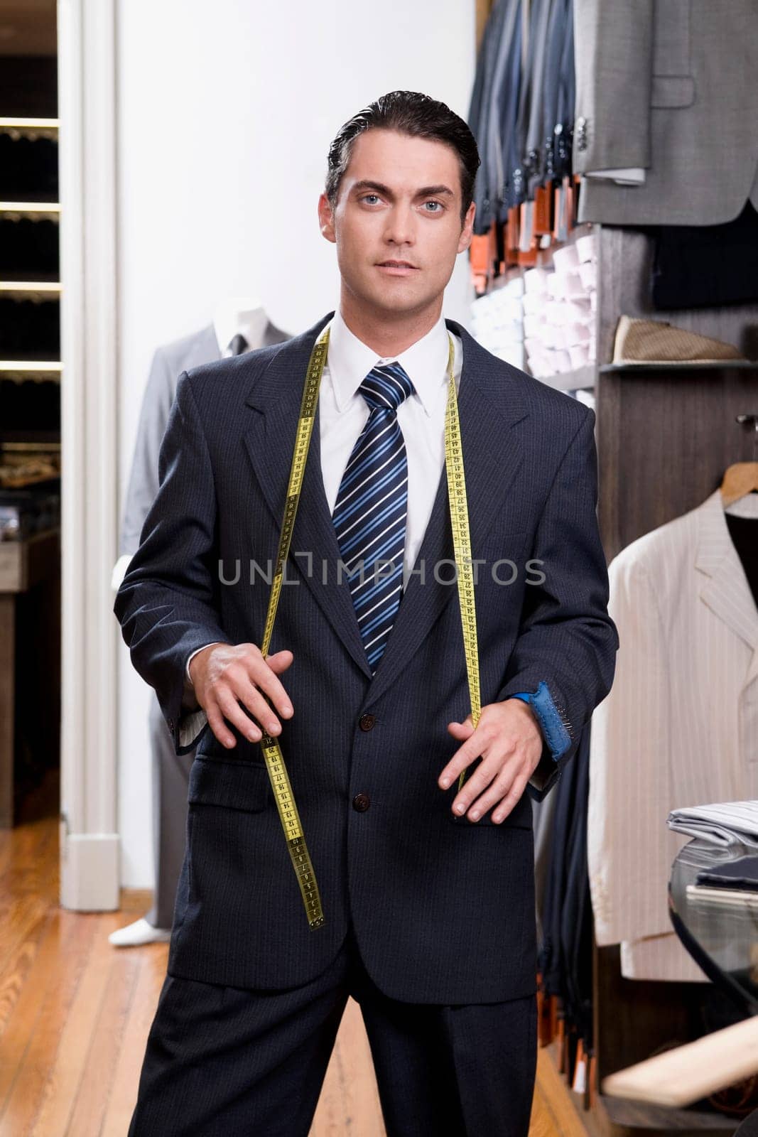 Portrait of a tailor holding a tape measure
