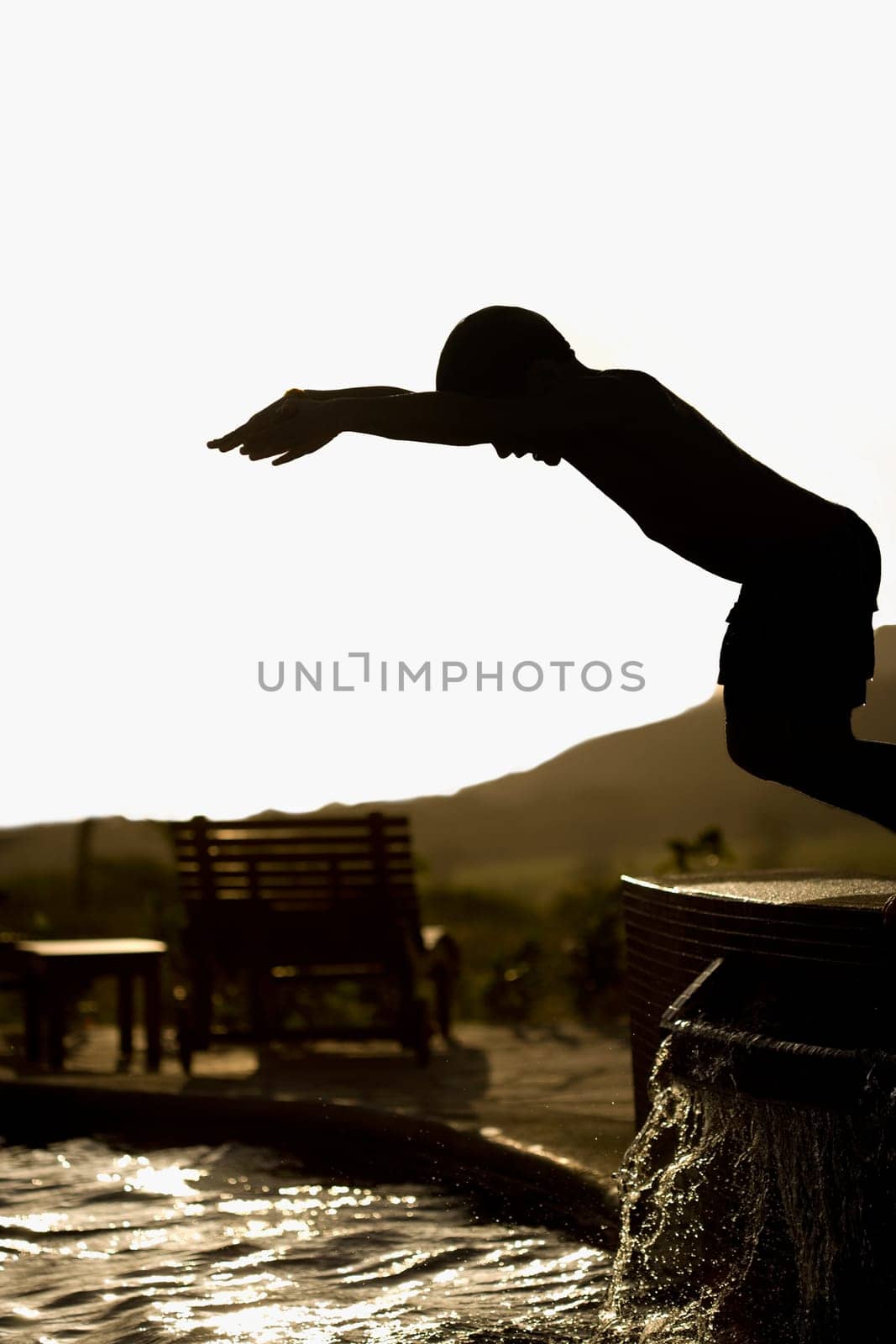 Boy preparing to jump into a swimming pool
