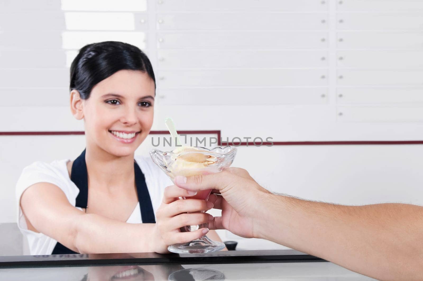 Female ice cream seller giving ice cream to a customer