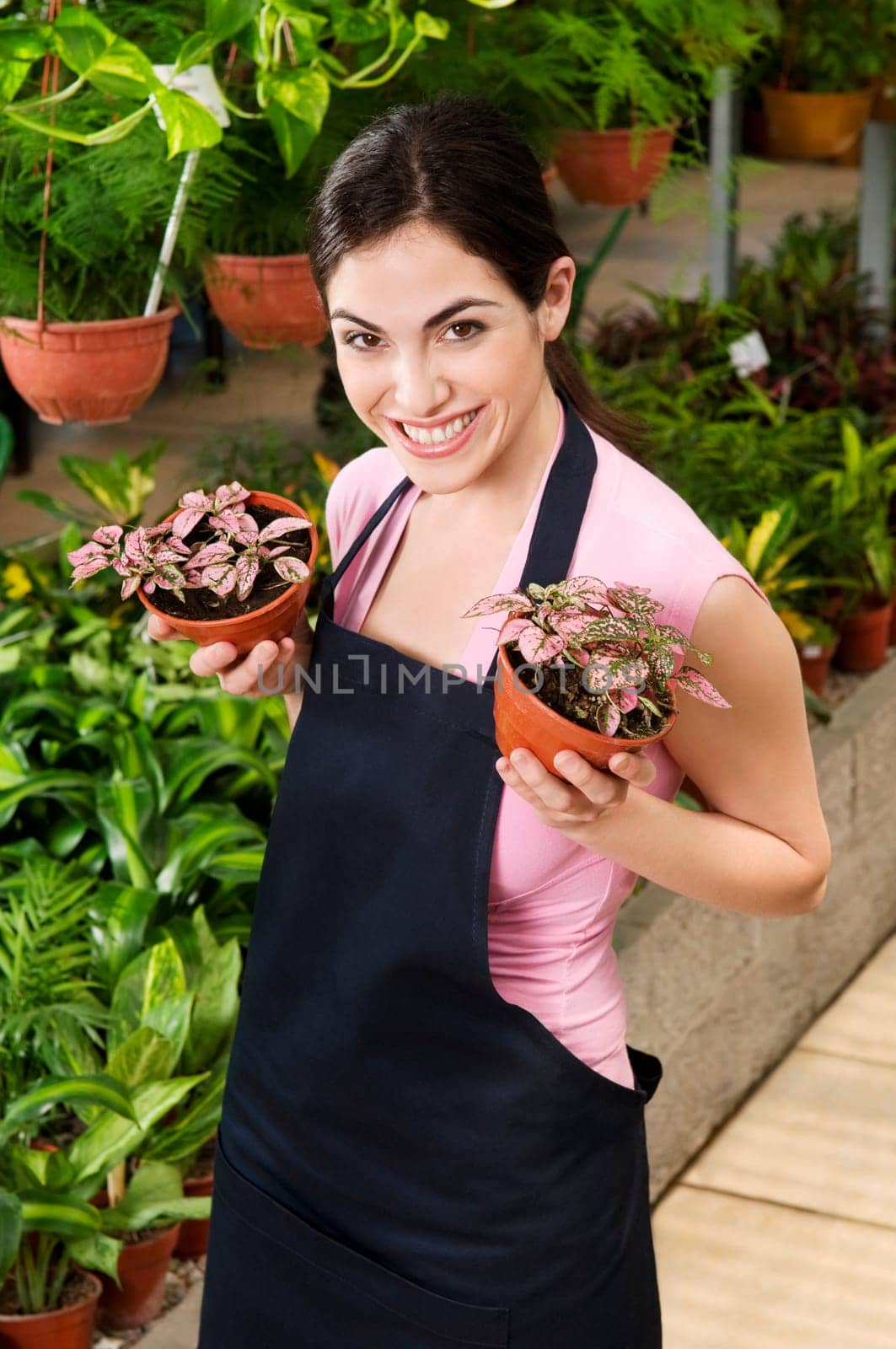 Woman holding potted plants in a greenhouse