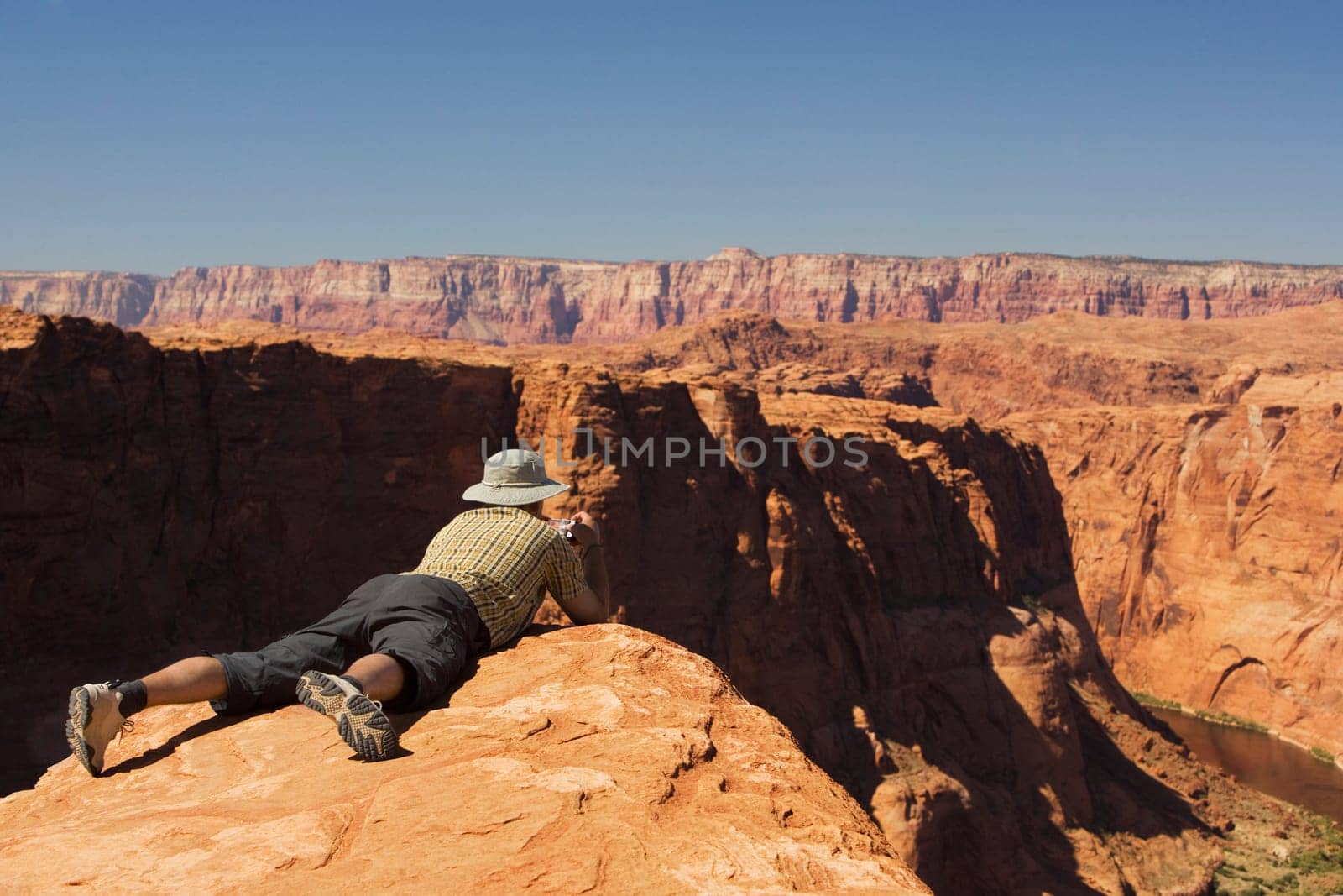 Man taking a picture of cliffs, Horseshoe Bend, Page, Arizona, USA