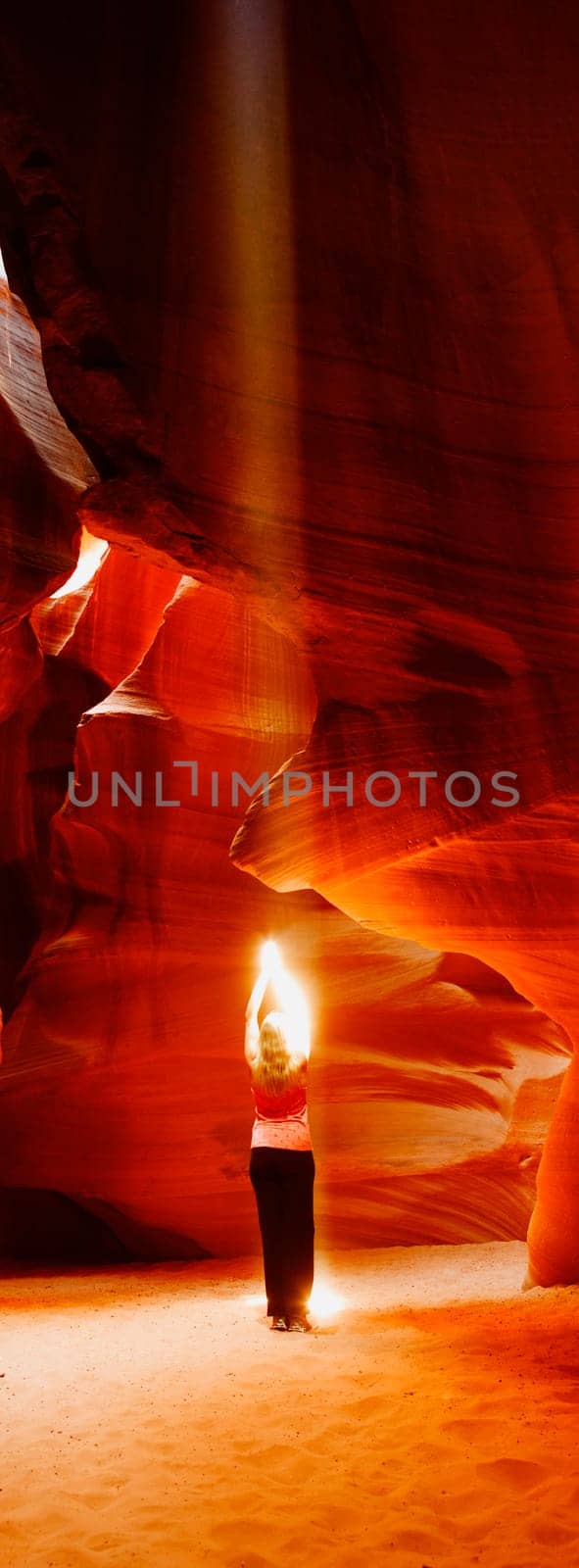 Sunbeam falling on a woman in a canyon, Antelope Canyon, Page, Arizona, USA
