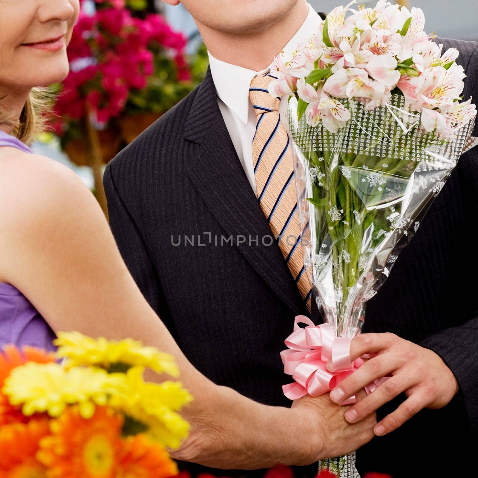 Female florist giving a bouquet of flowers to a customer