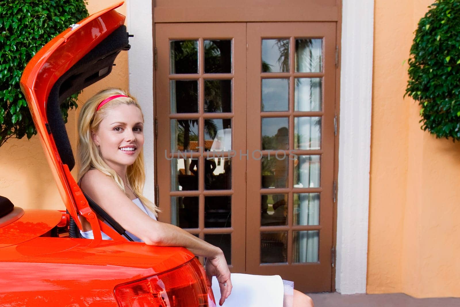 Woman sitting in a car trunk and smiling, Biltmore Hotel, Coral Gables, Florida, USA