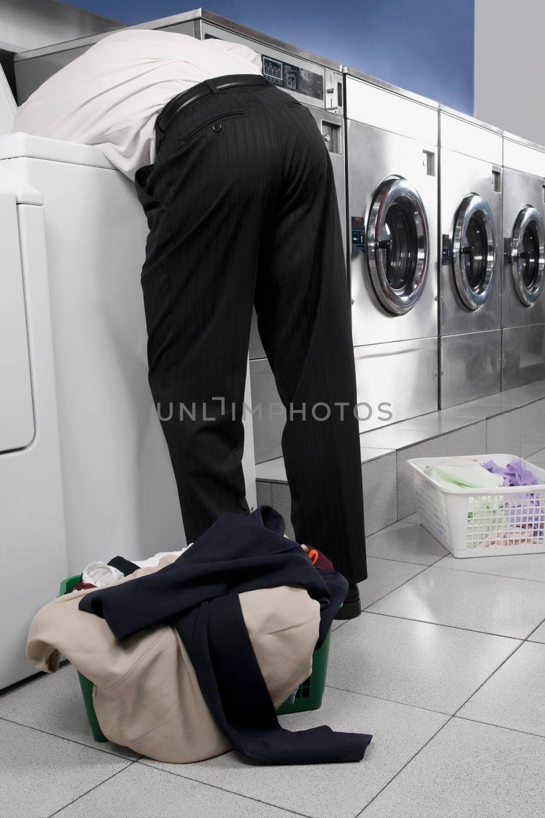 Businessman looking inside the washing machine in a laundromat