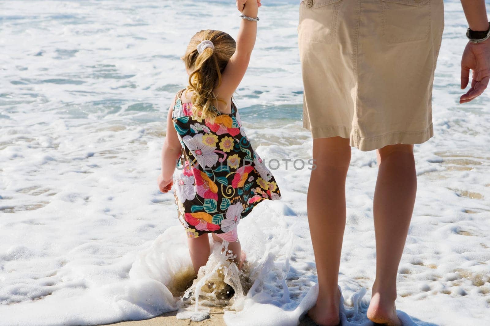Baby girl with her mother walking on the beach, Cabo San Lucas, Mexico