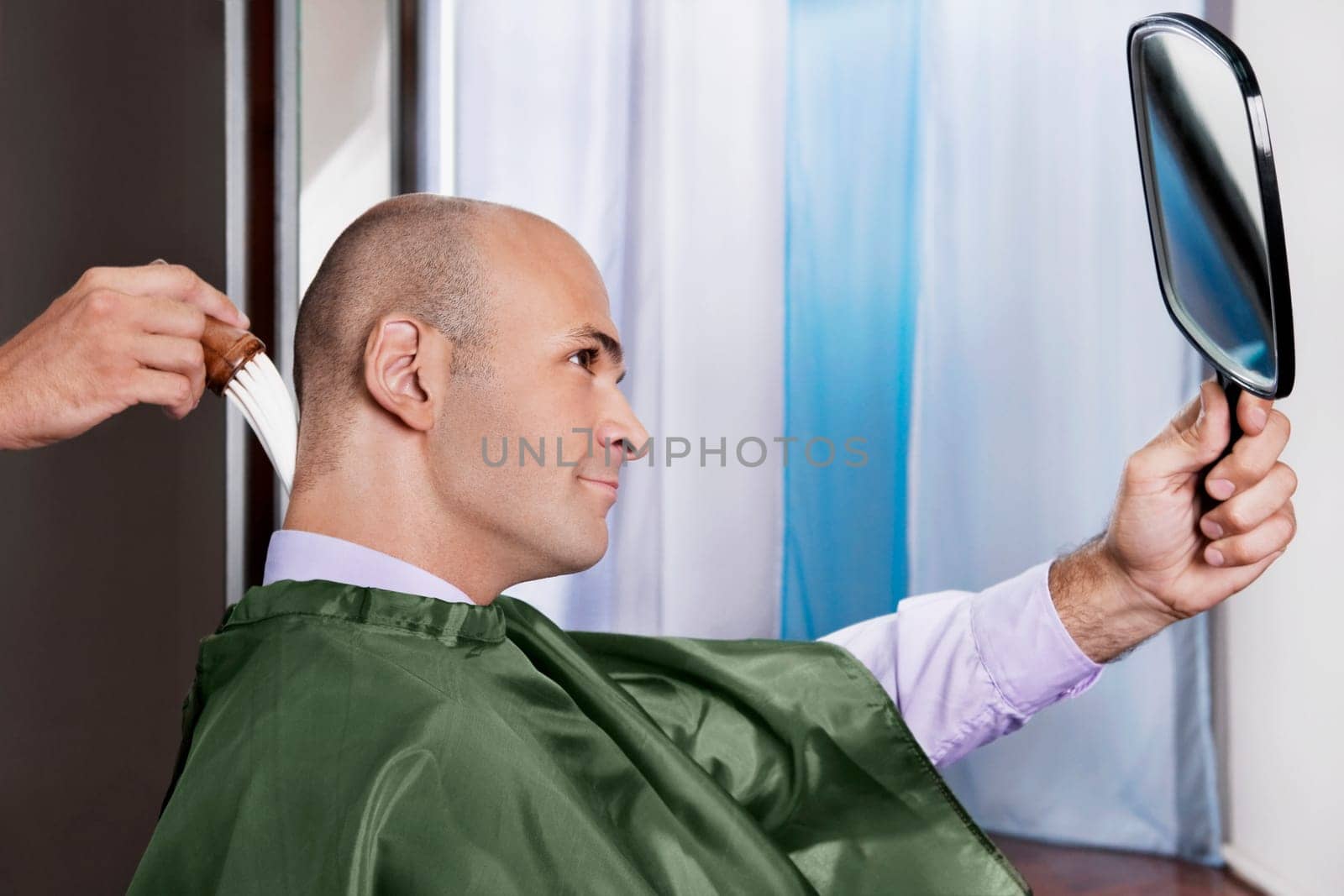 Man looking himself in a mirror after a haircut