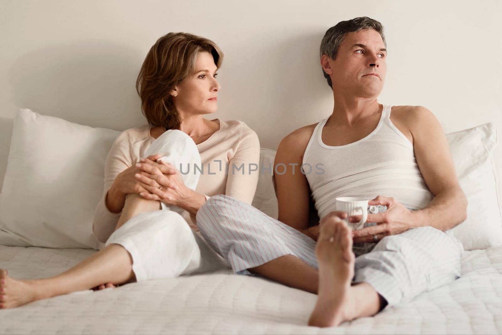Couple looking serious on the bed