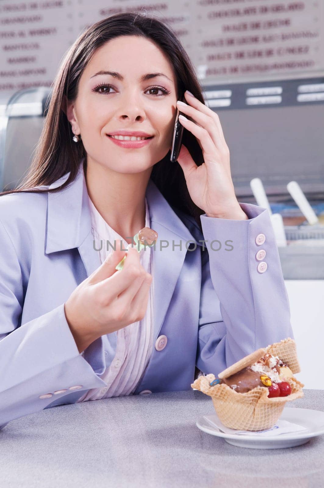 Woman eating ice cream and talking on a mobile phone