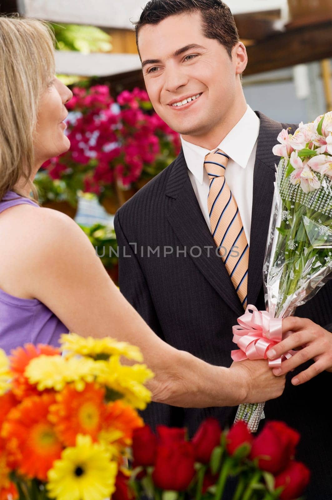 Female florist giving a bouquet of flowers to a customer