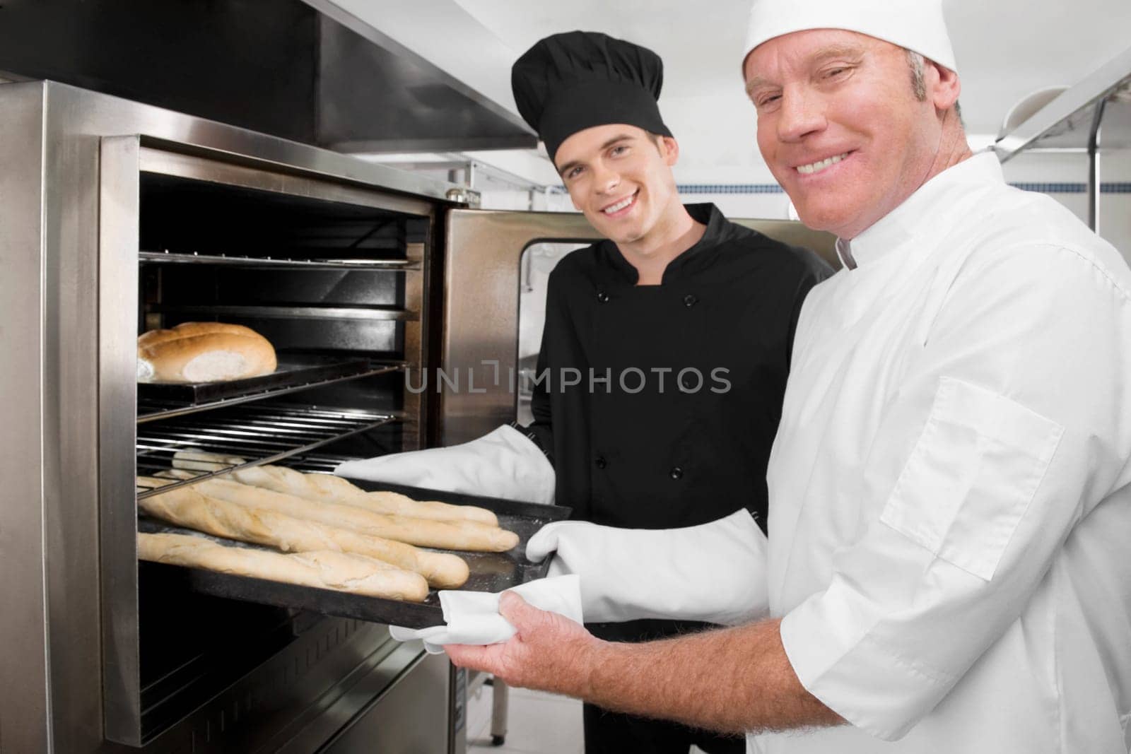 Two chefs preparing food in the kitchen