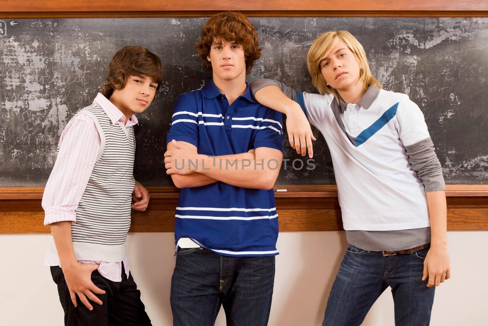 Three students standing in front of a blackboard