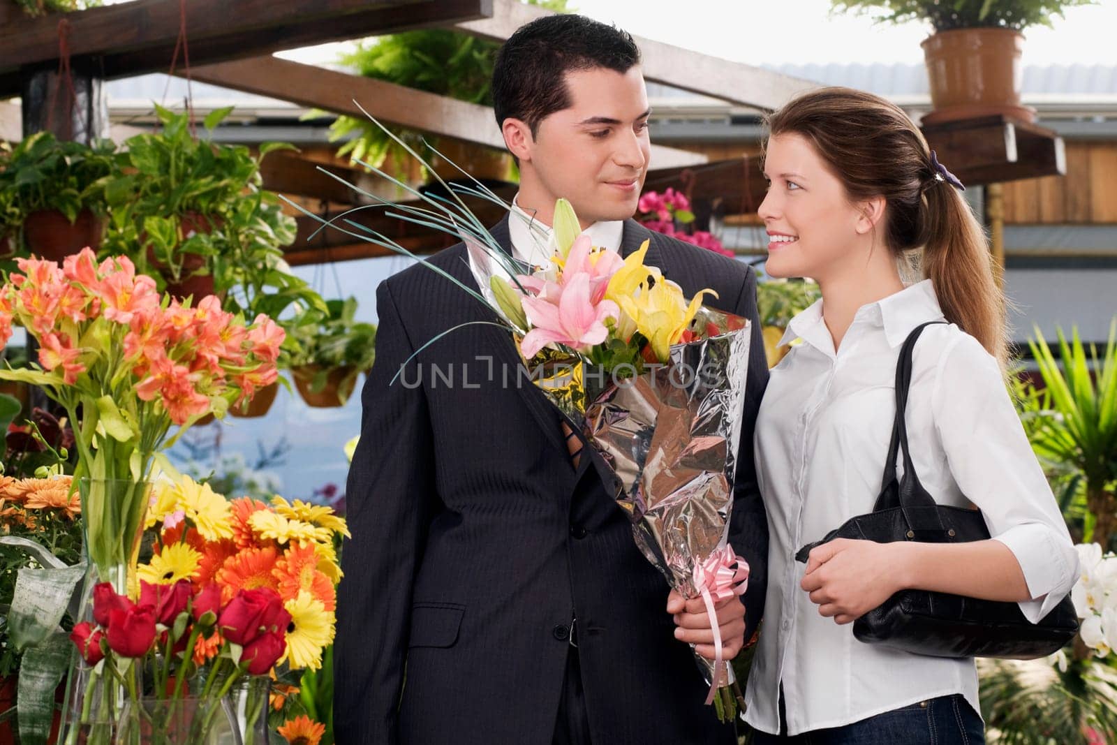 Couple with a bouquet of flowers in a florist shop