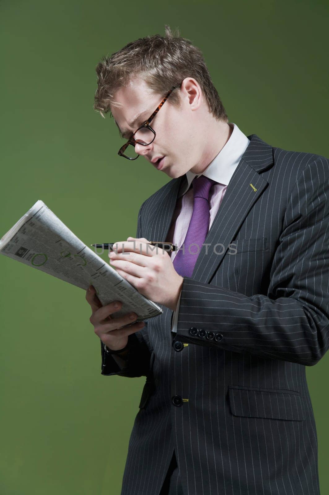 Close_up of a businessman marking on a newspaper