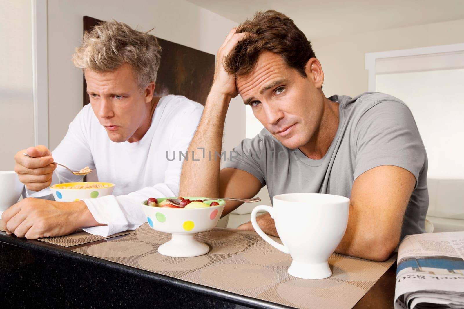 Men frowning at bowls of cereal and fruits