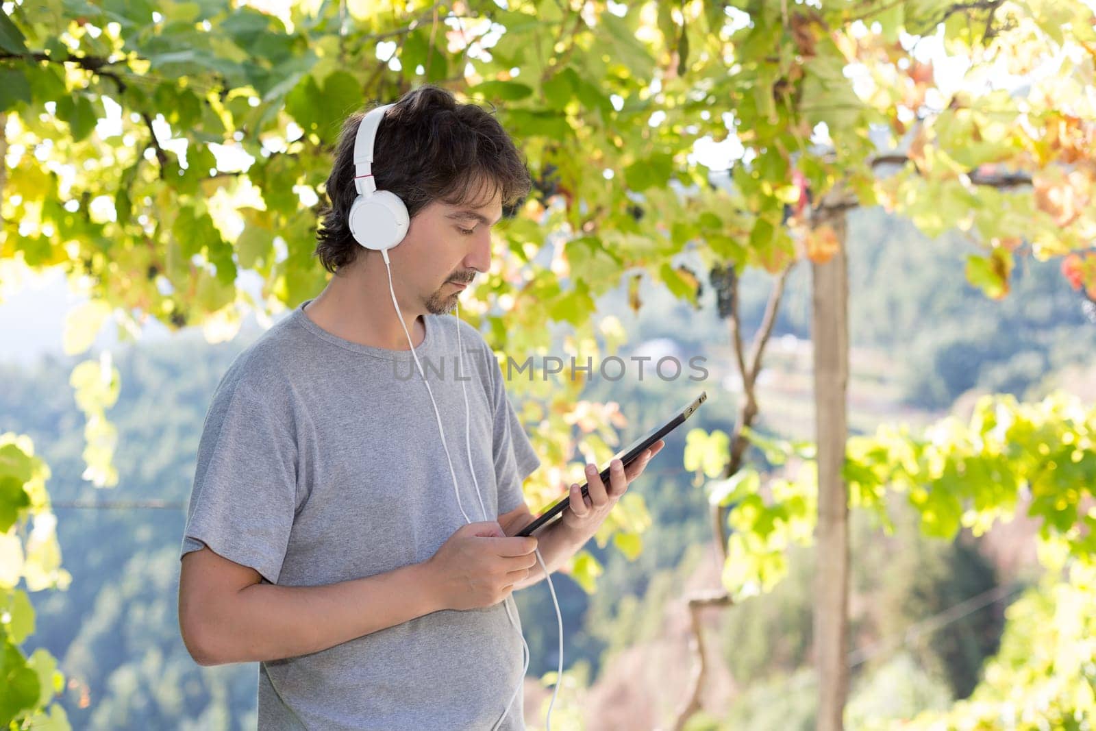 Young man relaxing with a tablet computer at a garden