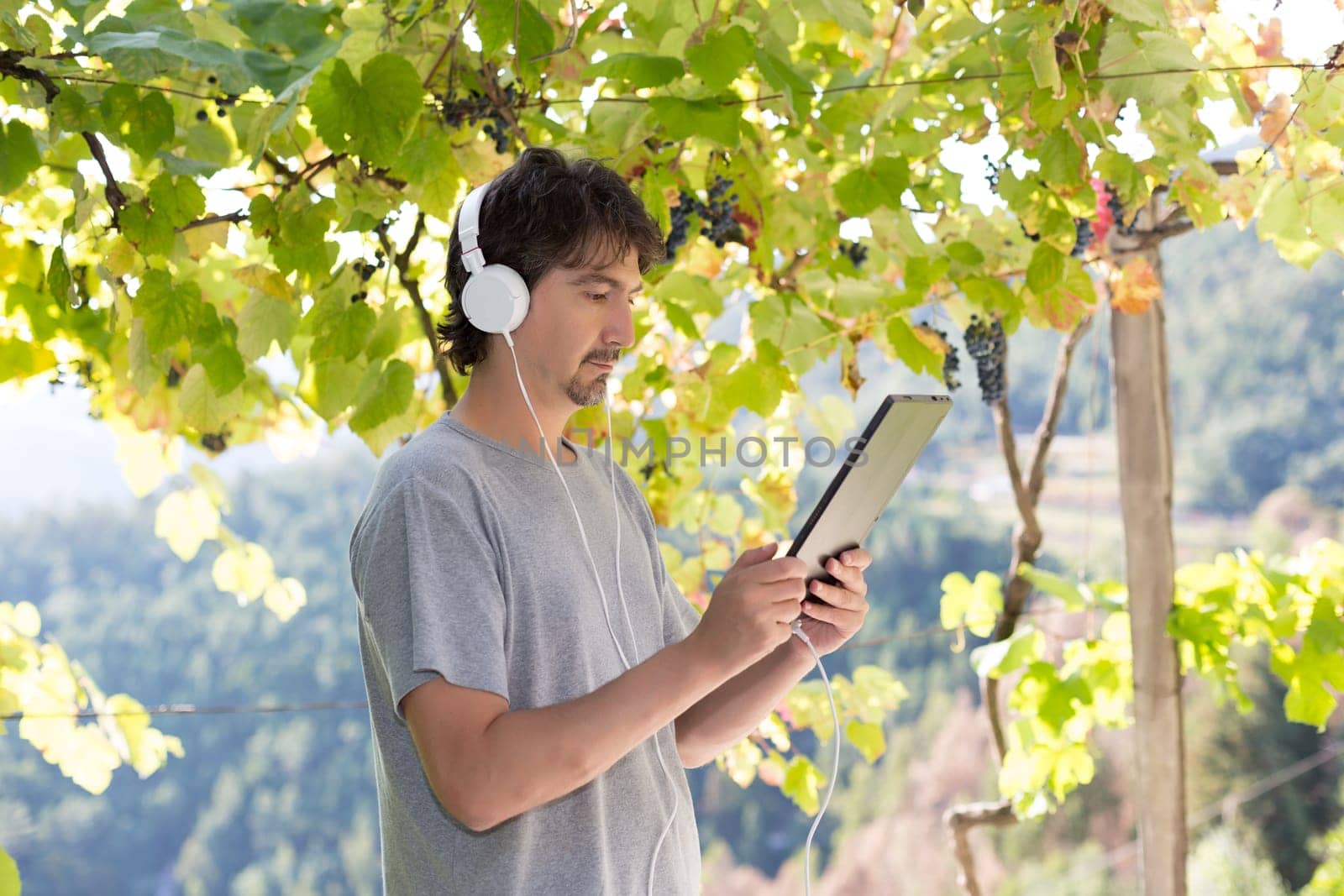 Young man relaxing with a tablet computer at a garden