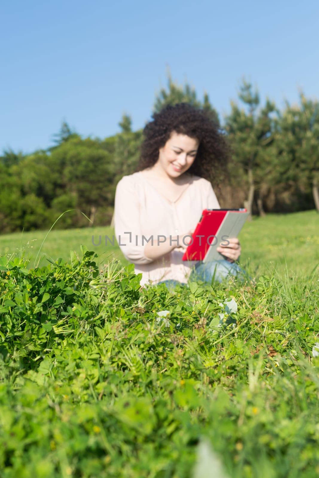 A beautiful young woman relaxing at the city park - Selective focus on the grass