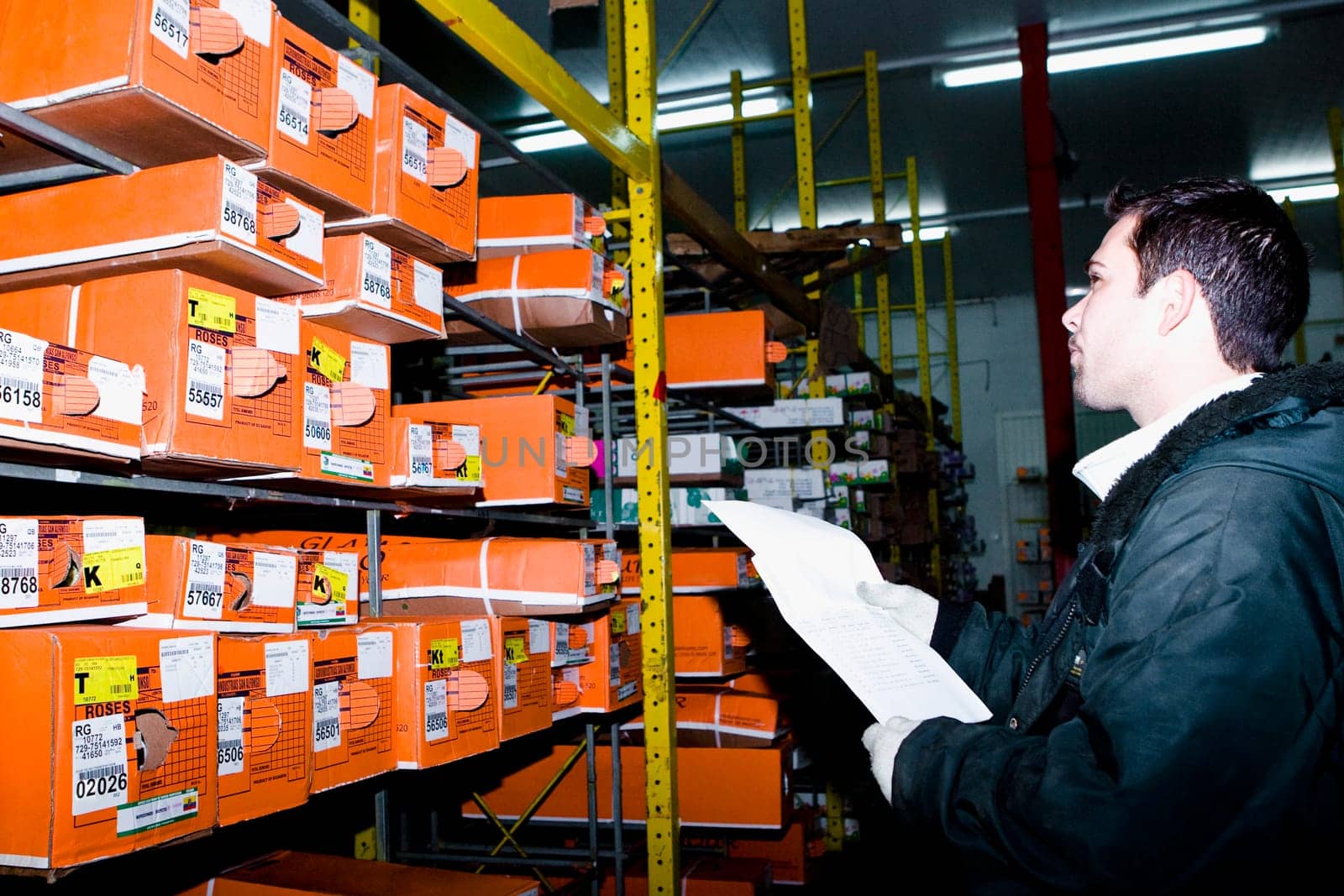 Man examining flower boxes in a warehouse, Miami, Florida, USA
