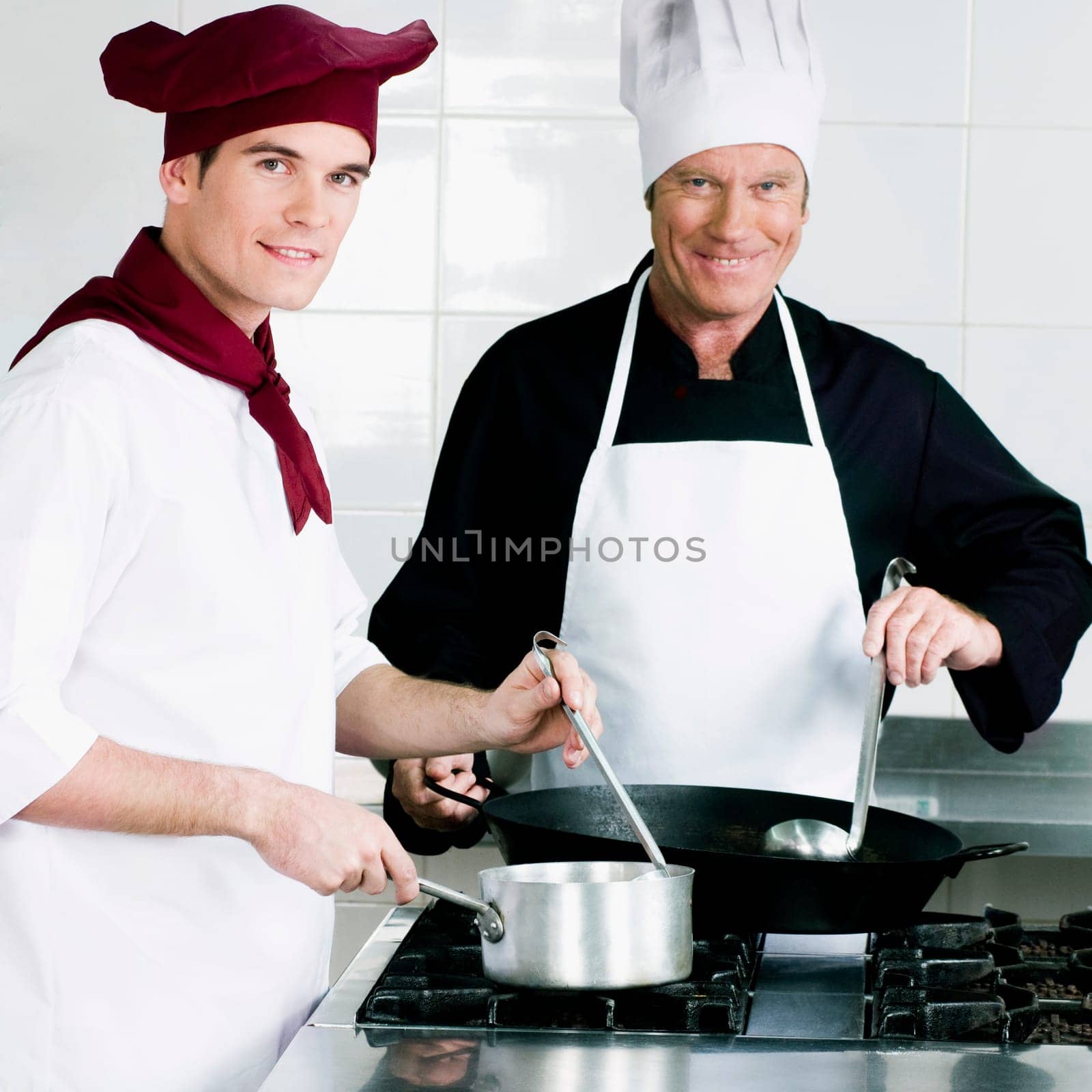 Two chefs cooking food in the kitchen