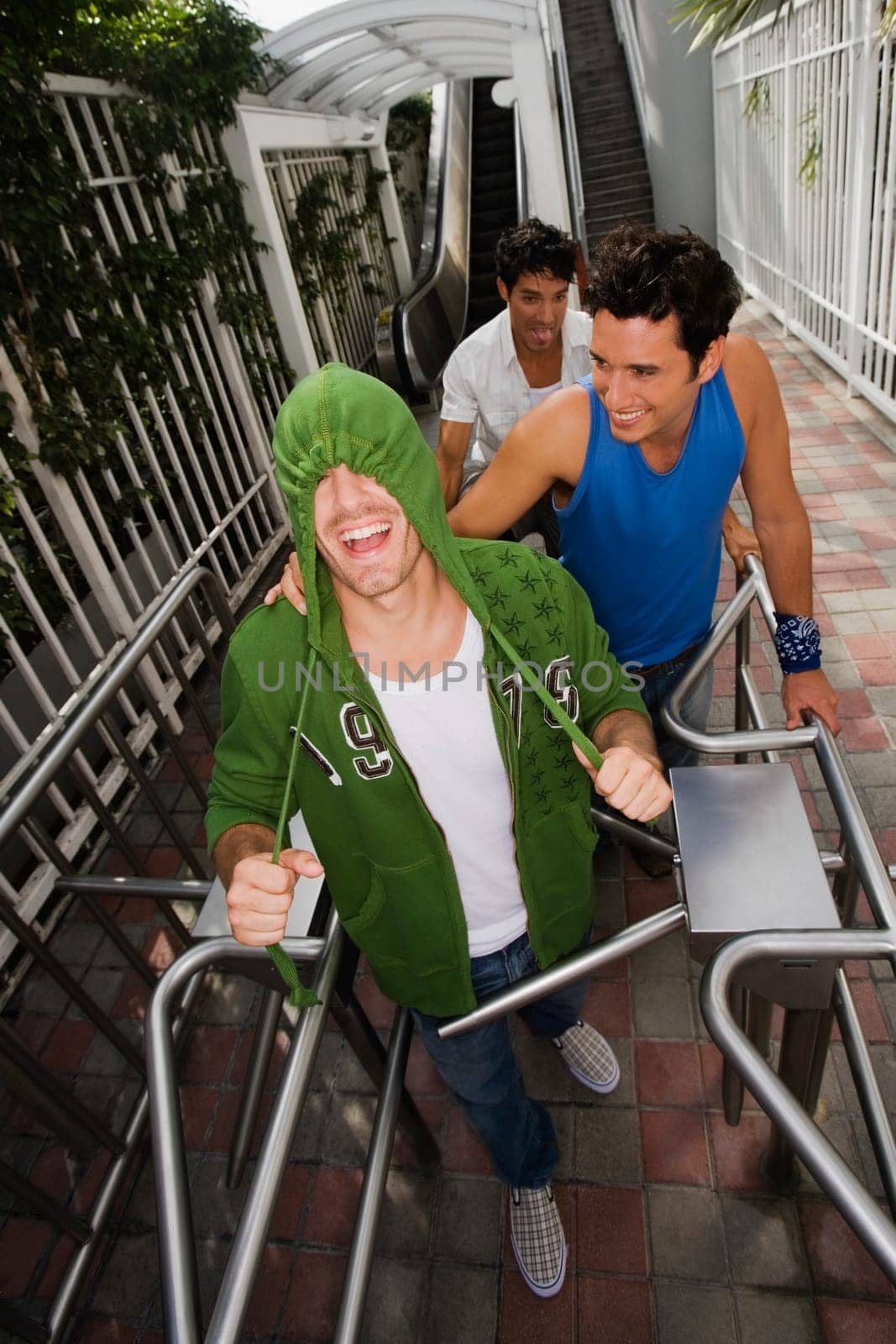 High angle view of three young men standing in front of an escalator