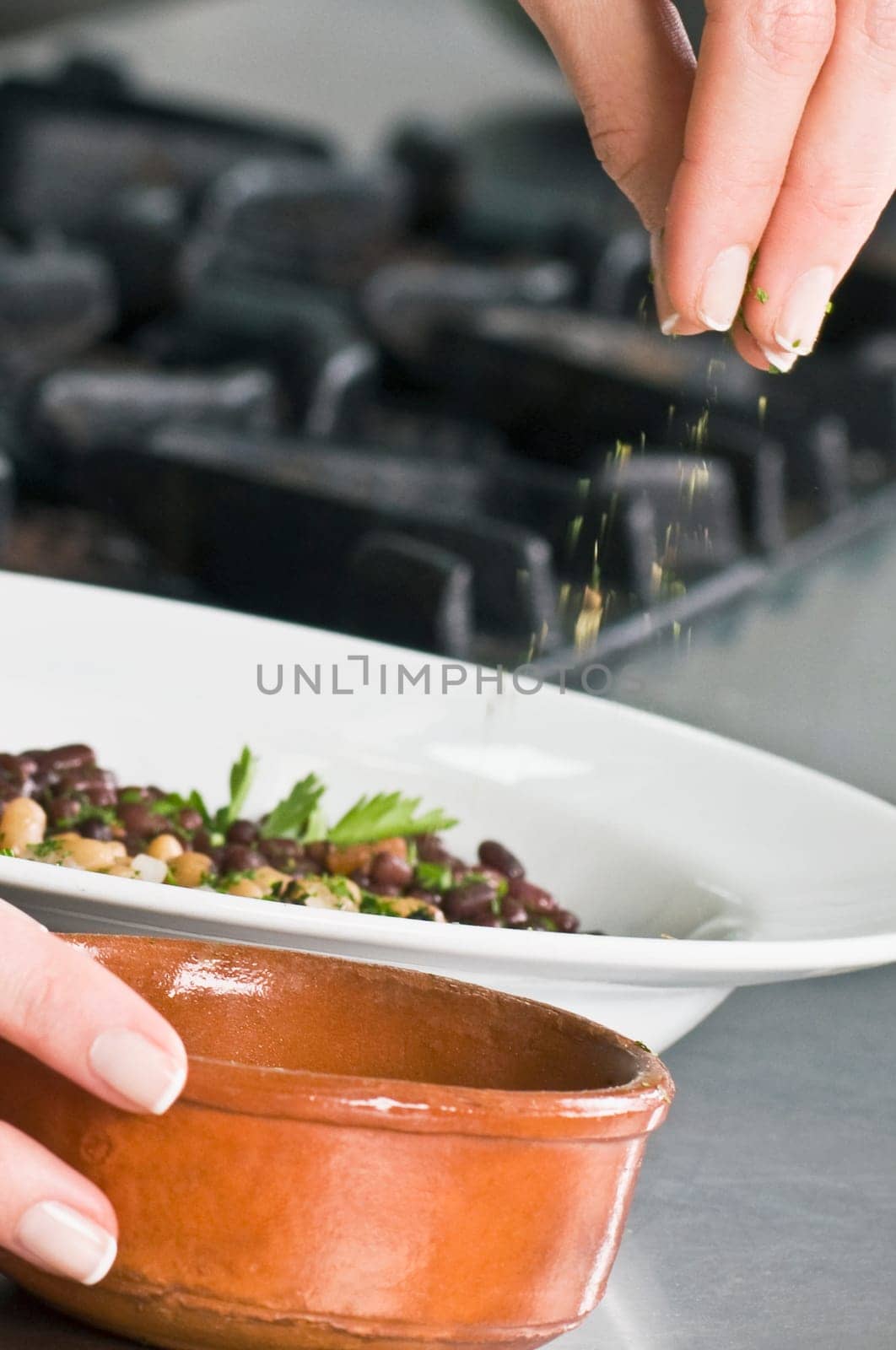 Woman sprinkling cilantro to beans