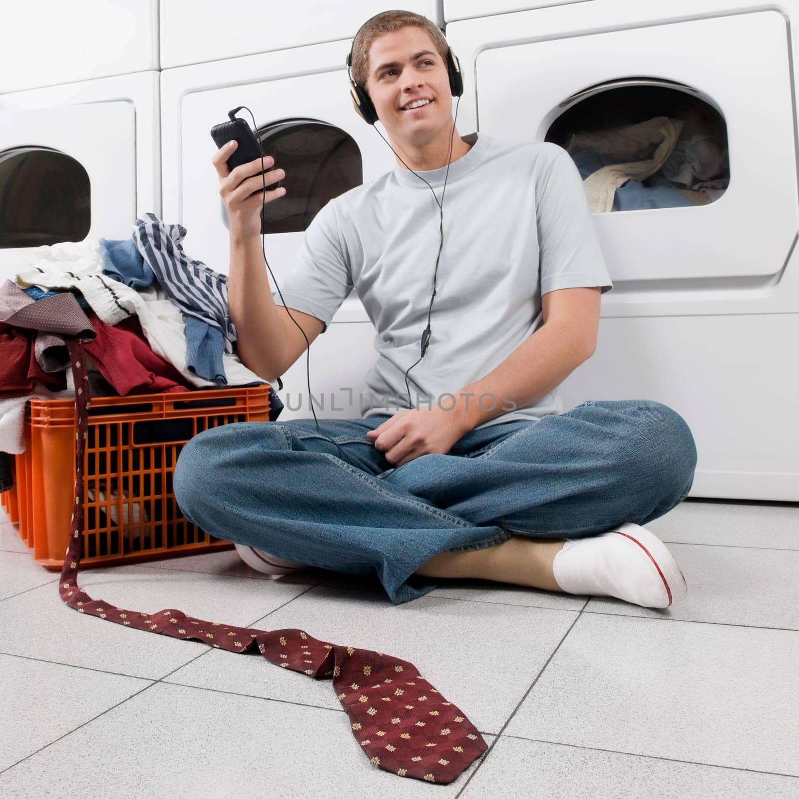Man listening to an MP3 player in a laundromat