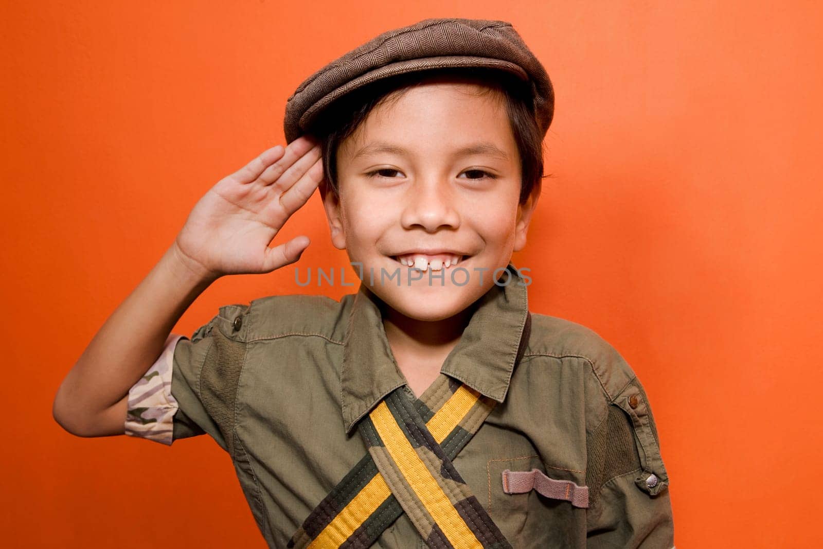 Close_up of a boy saluting