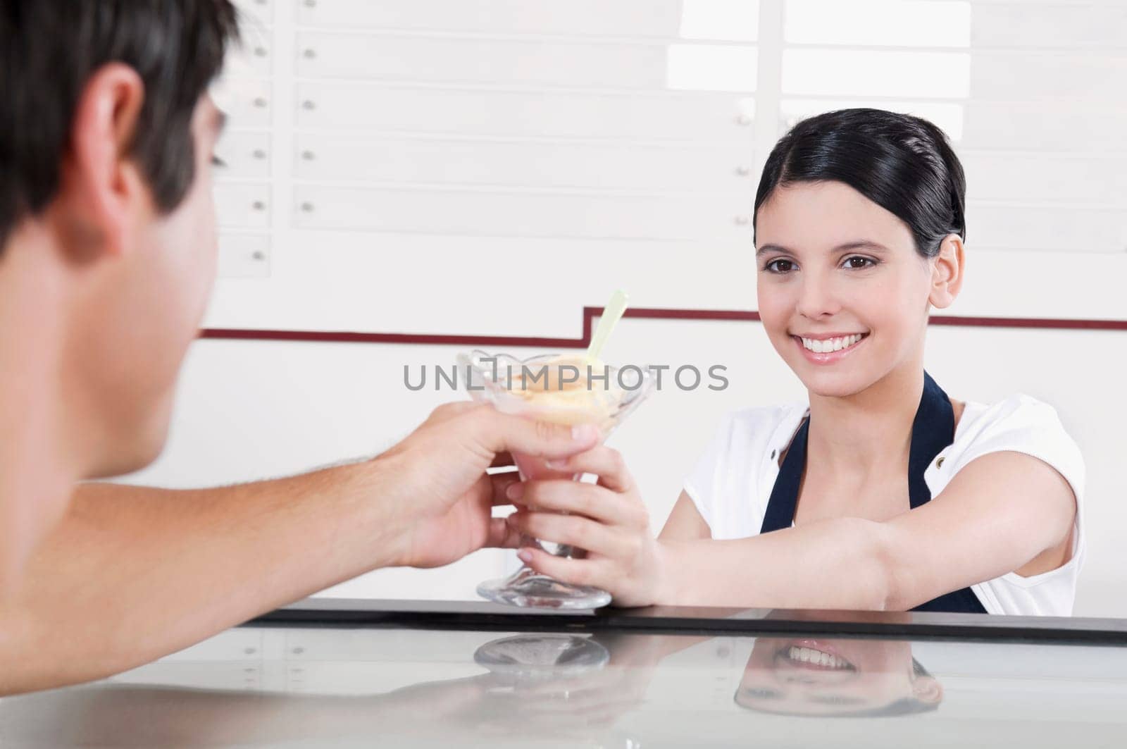 Female ice cream seller giving ice cream to a customer