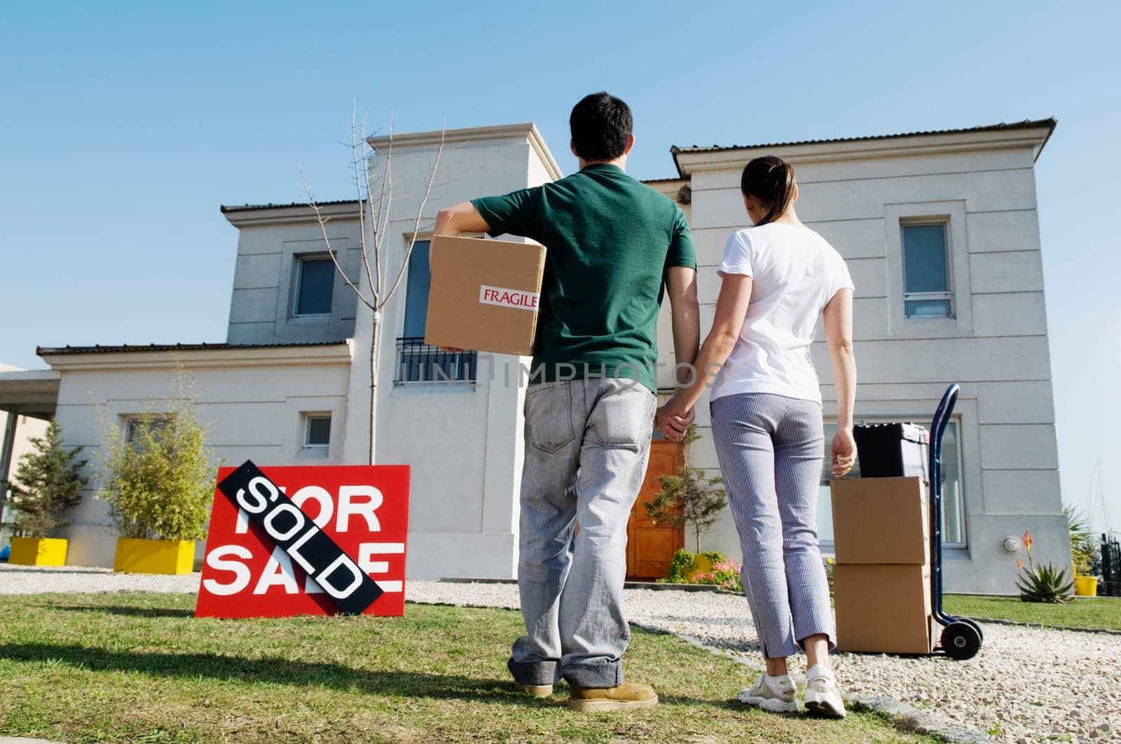 Rear view of a young couple looking at a house