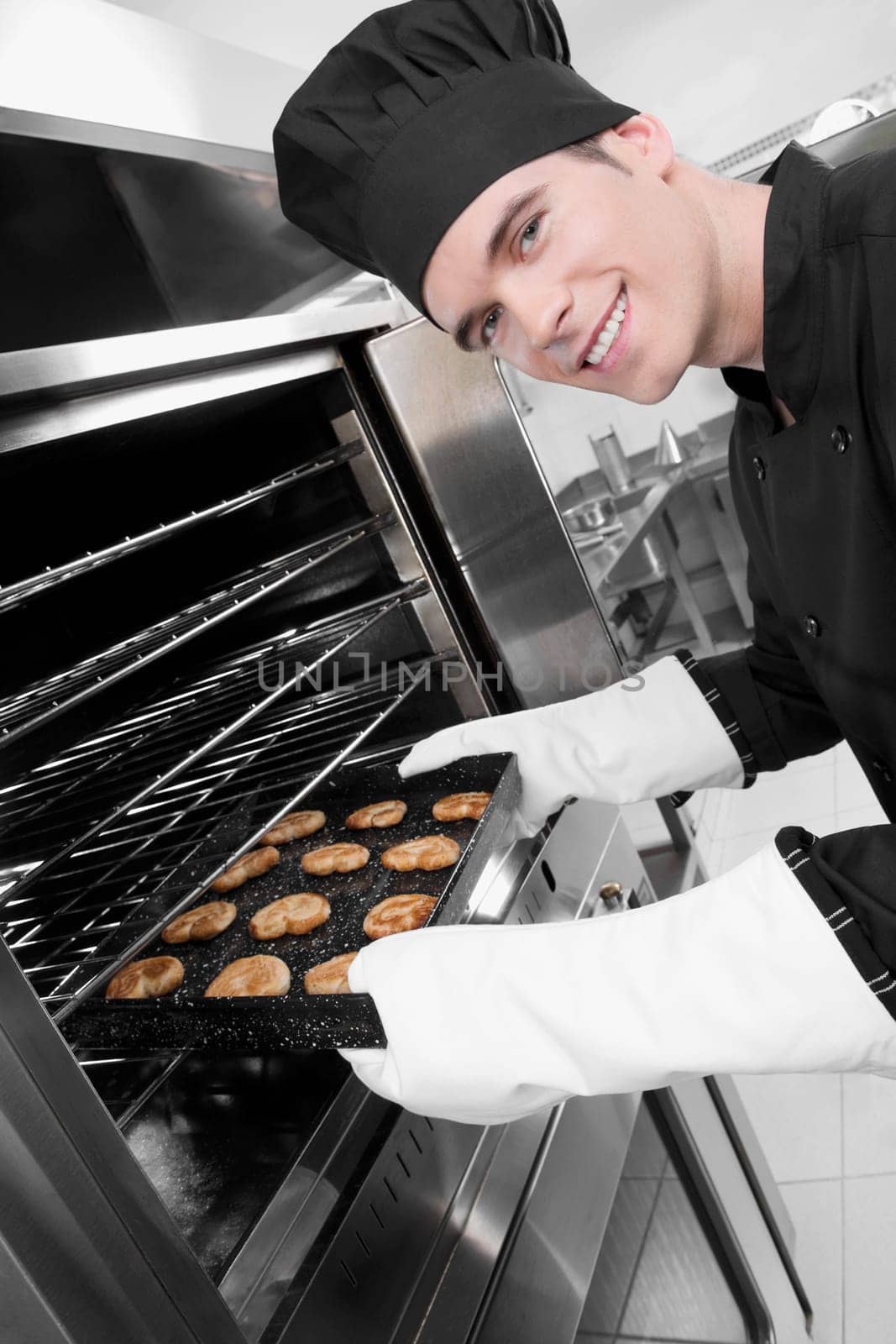 Chef taking out a tray of cookies from an oven