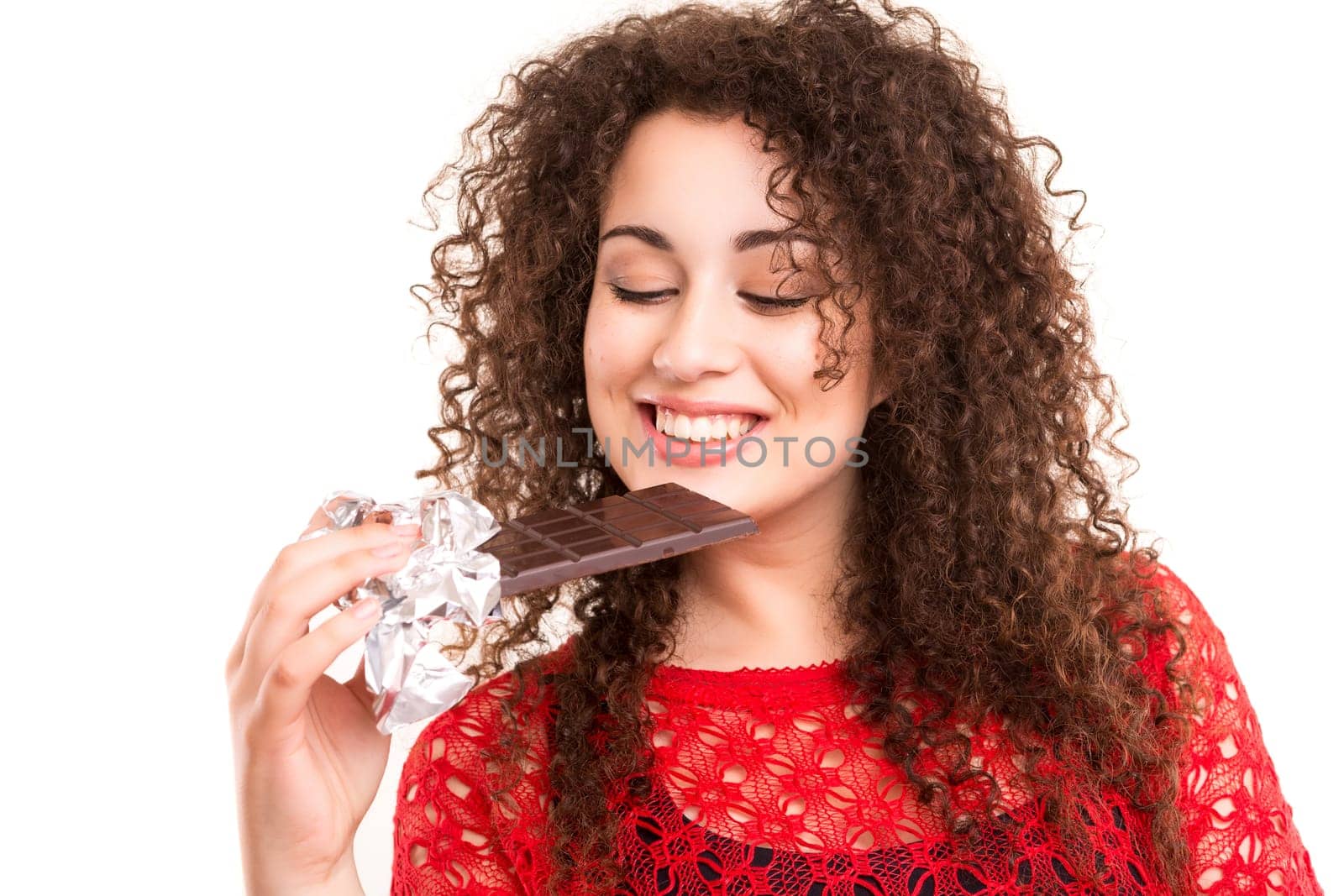 Beautiful young woman eating a chocolate bar