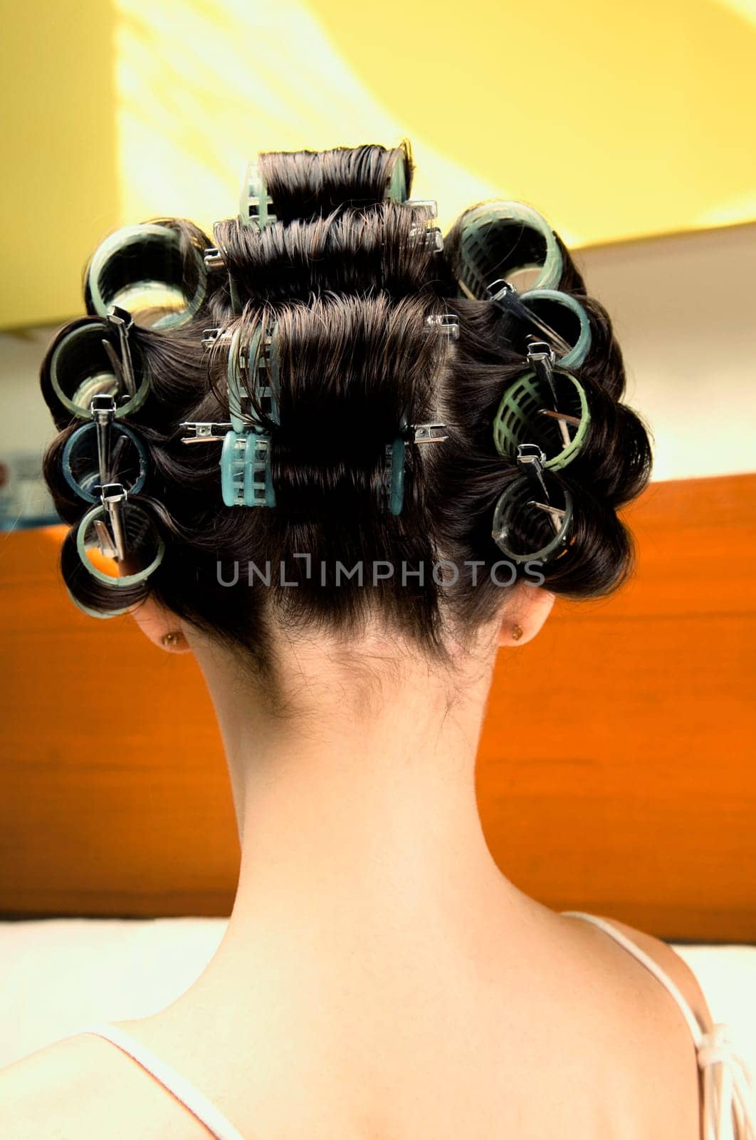 Rear view of a young woman wearing hair rollers