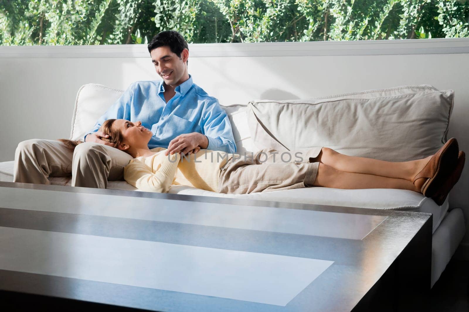 Mid adult woman lying on a mid adult manŽs lap and smiling