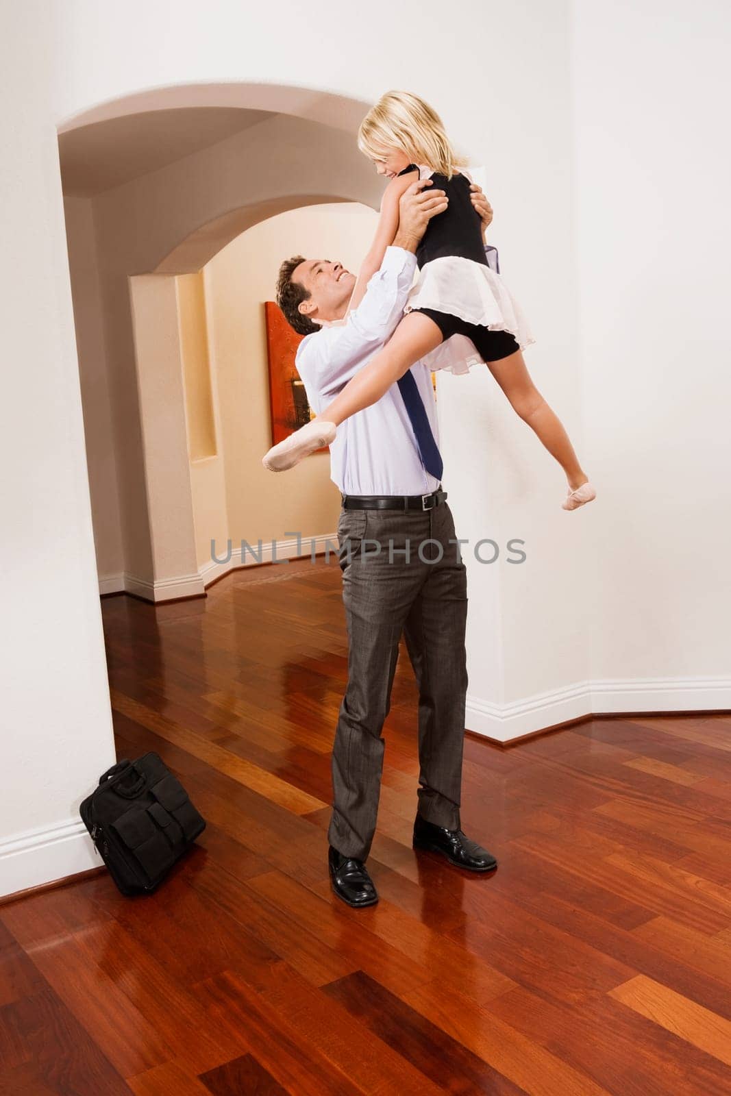Businessman picking up his daughter