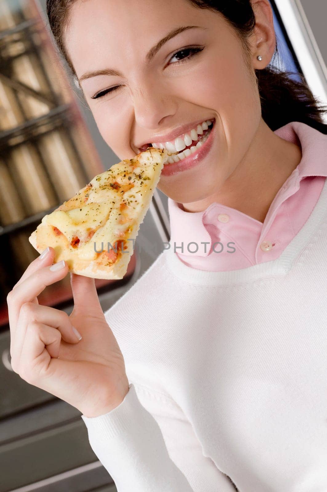 Female chef eating a slice of pizza