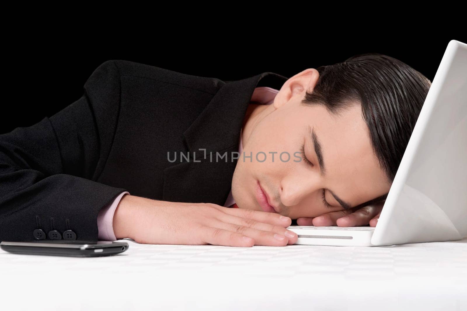 Businessman sleeping next to laptop