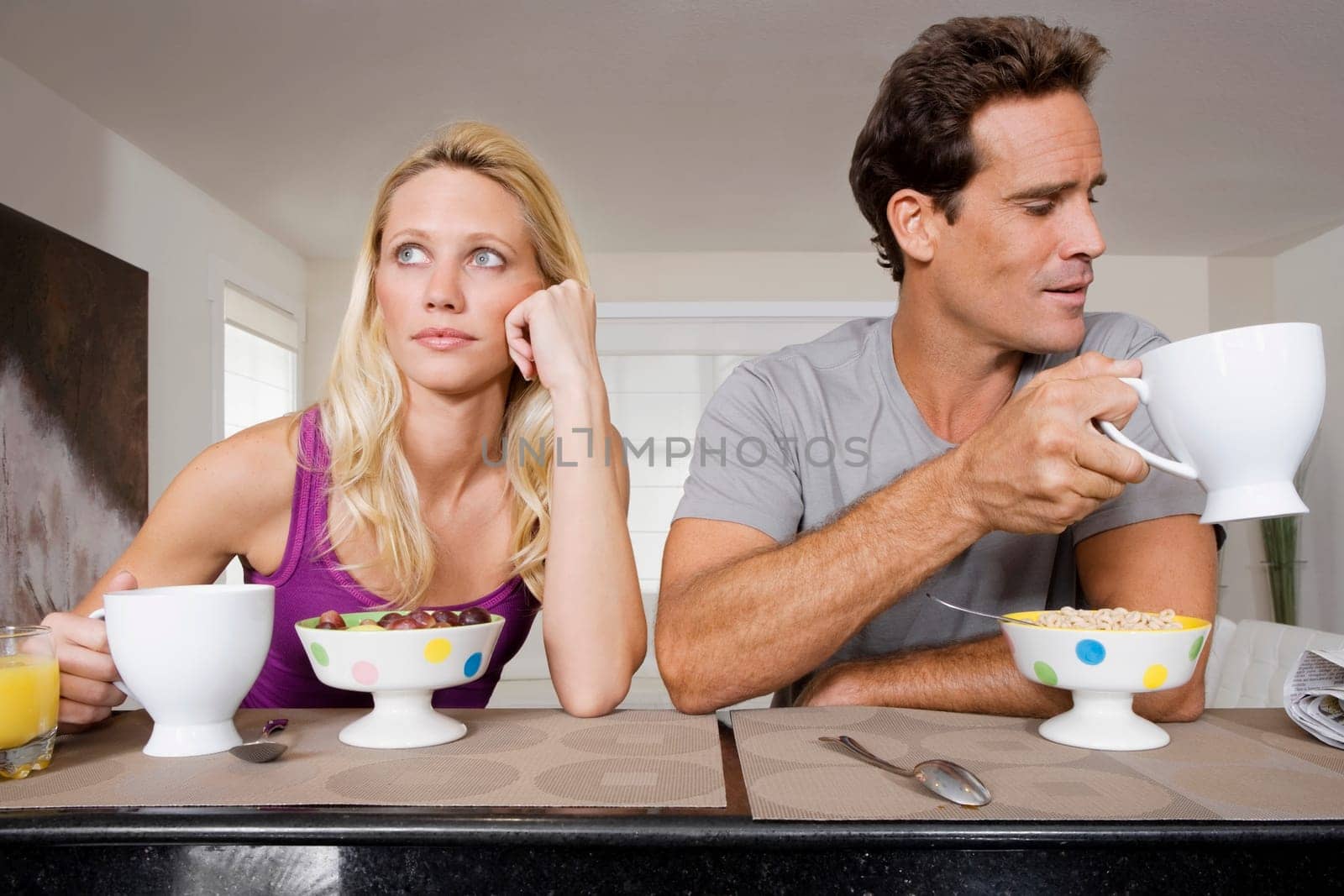 Couple ignoring each other at breakfast