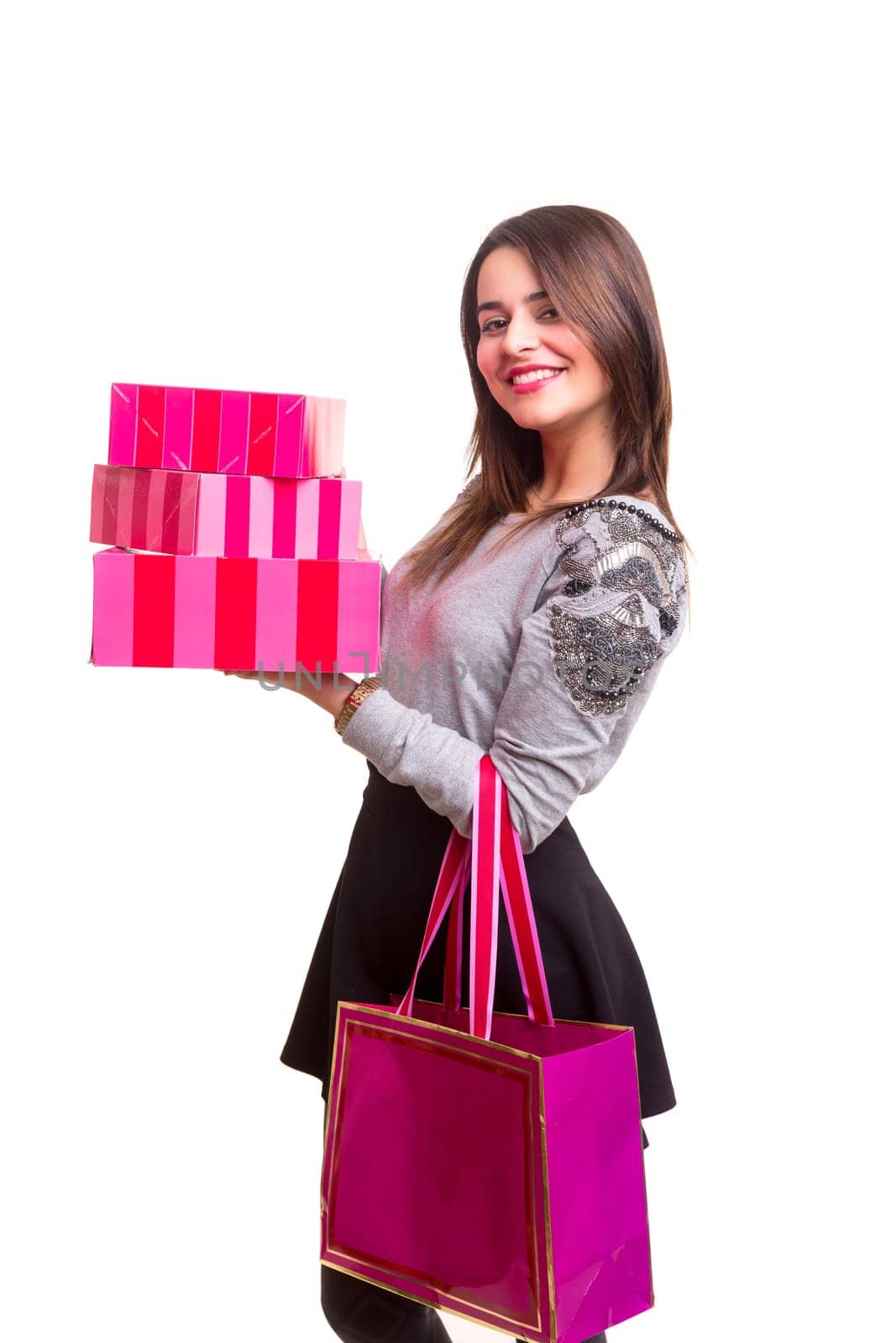 Studio shot of a young woman holding some gifts, isolated over white