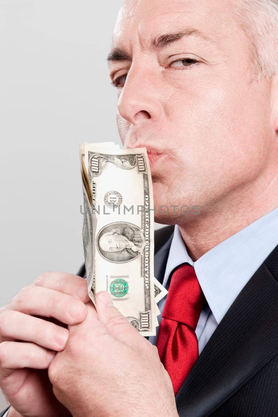 Businessman kissing currency notes in a clothing store
