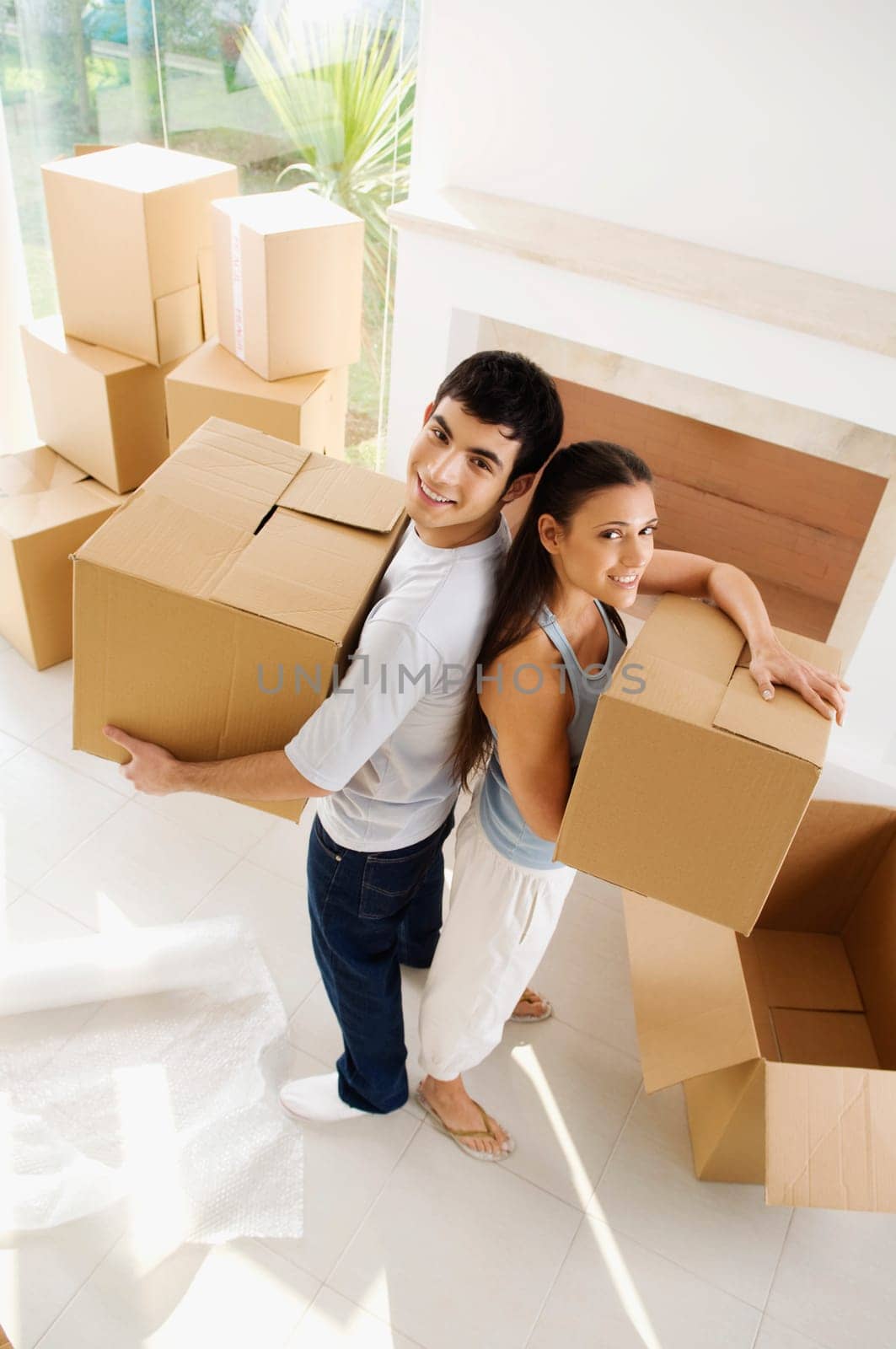 Portrait of a young couple holding cardboard boxes and smiling