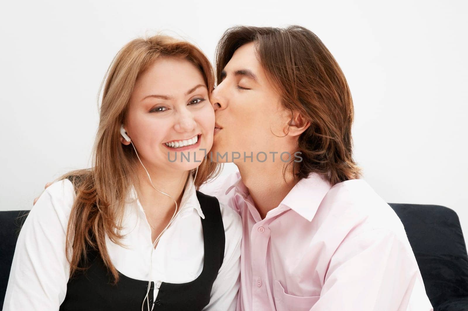 Portrait of a young man kissing a young woman on her cheek
