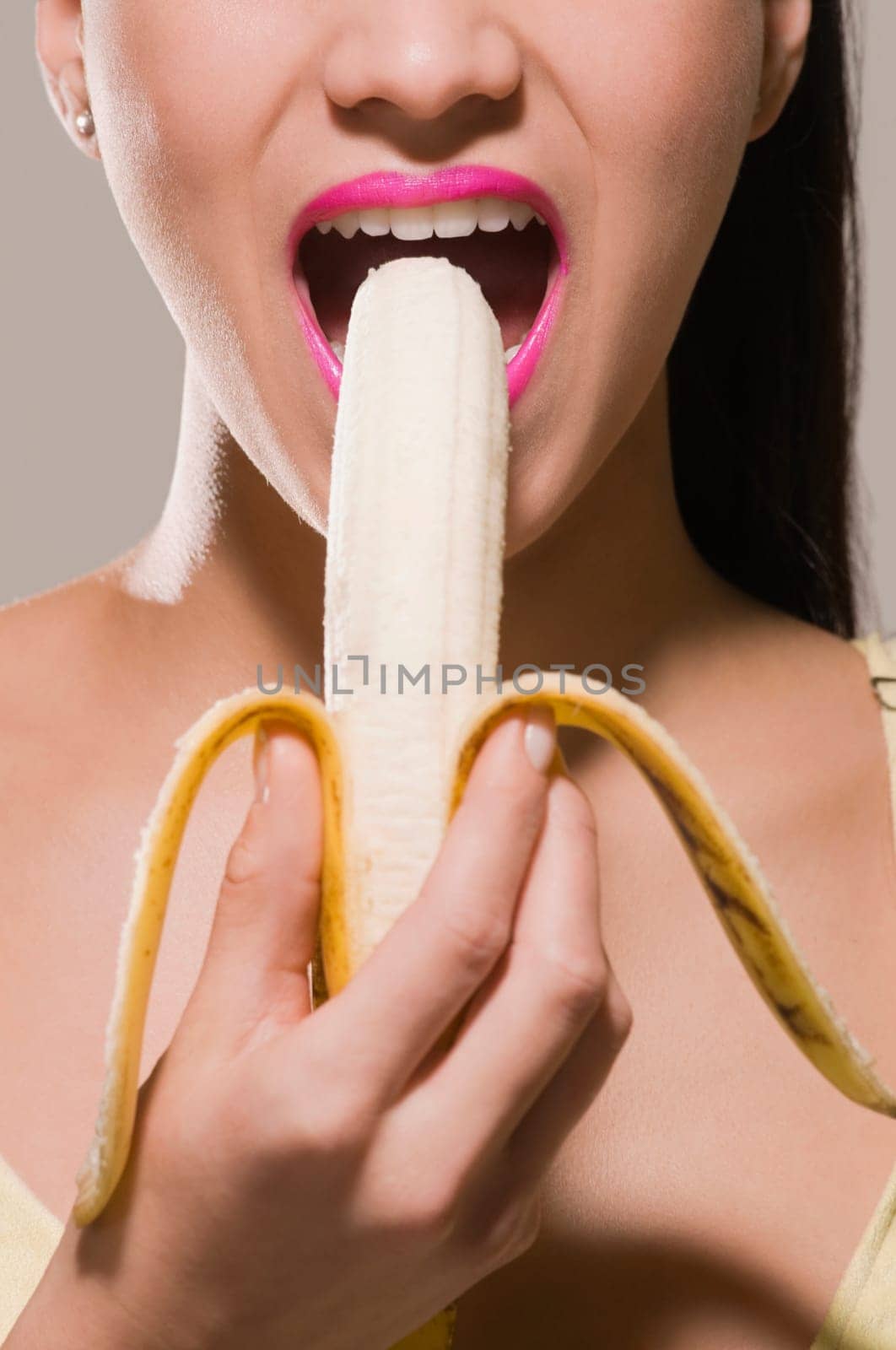 Close_up of a young woman eating a banana
