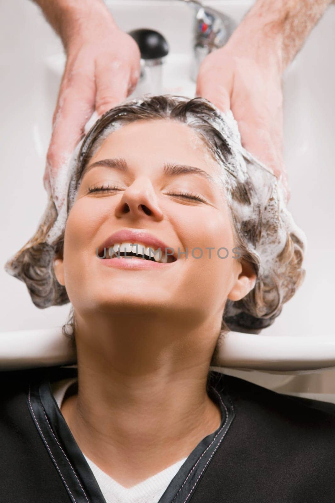 Young woman getting hair shampooed at the hair salon